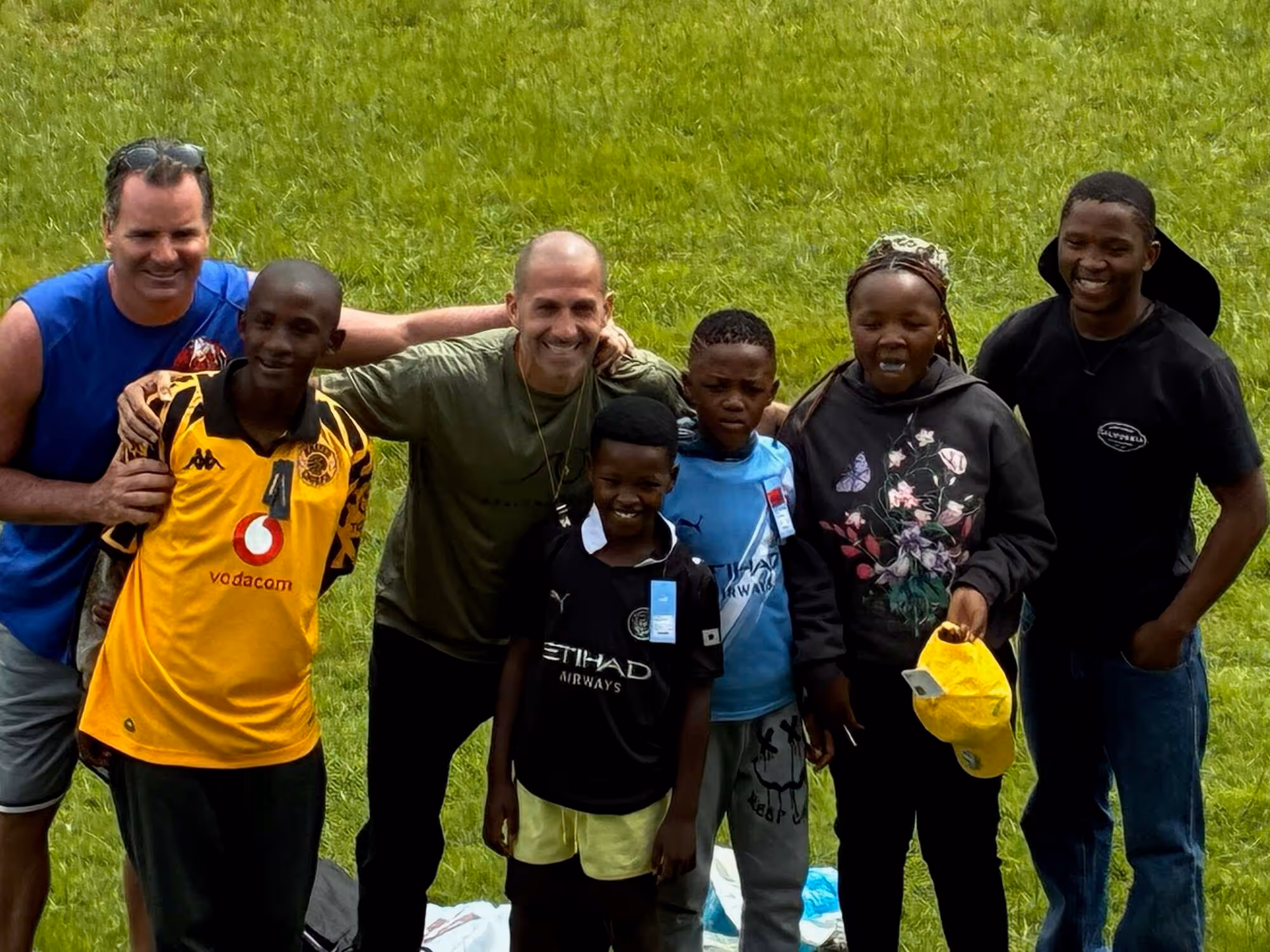 Group of diverse people standing together outdoors at church or hospital community event smiling.