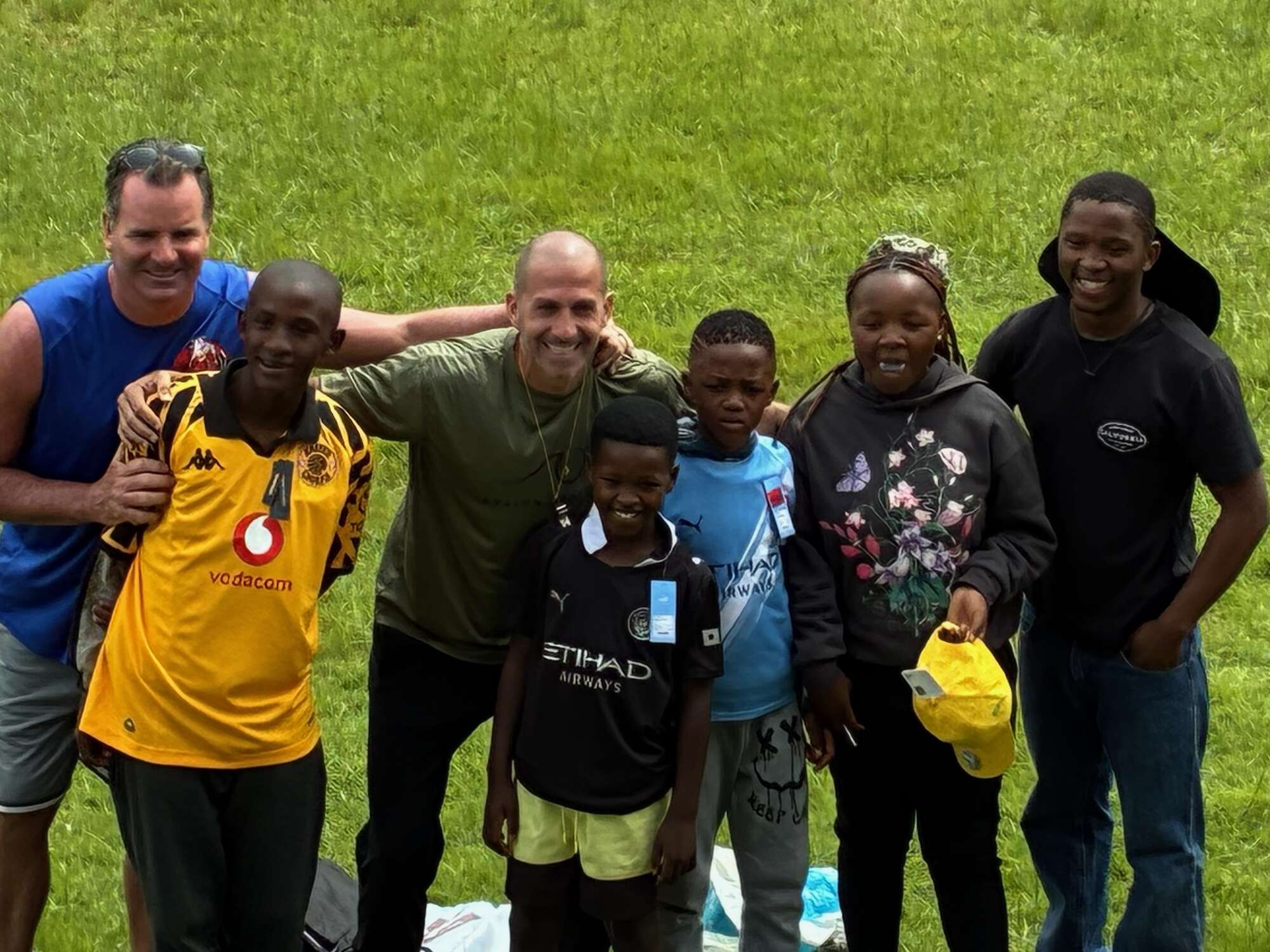 Group of diverse people standing together outdoors at church or hospital community event smiling.