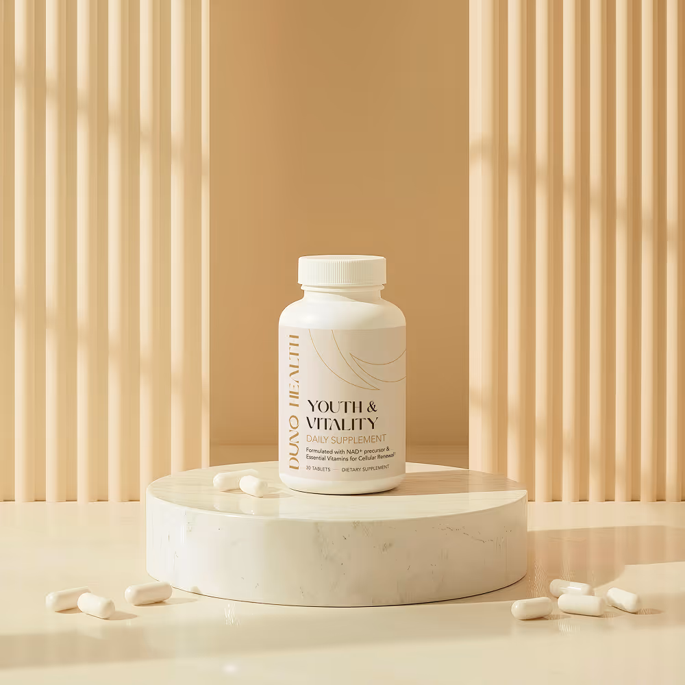 White bottle of DUNO Health Youth & Vitality daily supplement on a round marble pedestal with capsules scattered around, beige vertical blinds in background.