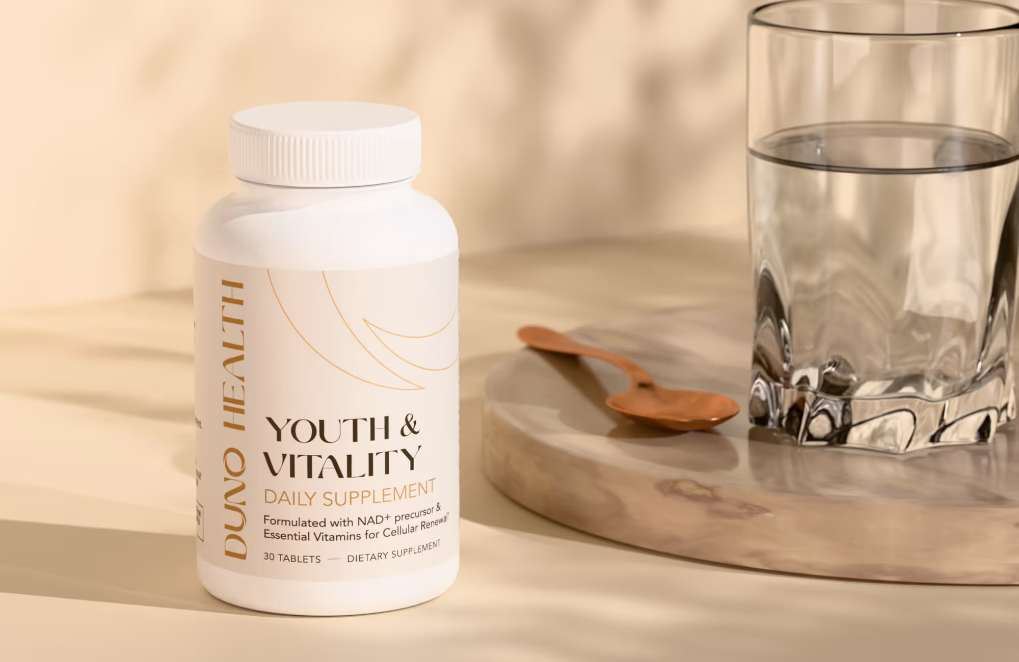 White bottle of Duno Health Youth & Vitality daily supplement next to a glass of water and a wooden spoon on a beige surface.