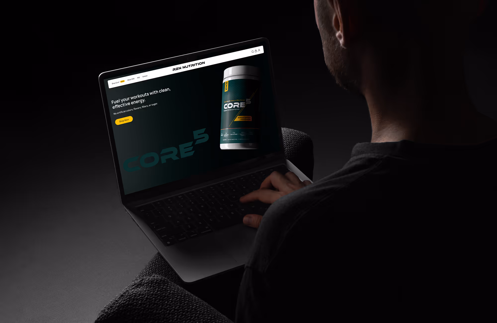 Person using laptop showing RZN Nutrition website with Core5 workout energy supplement displayed.