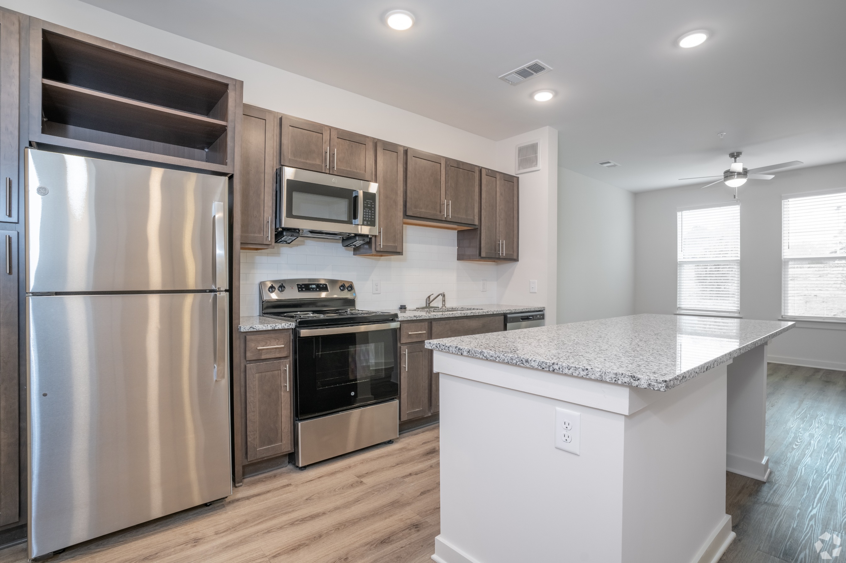 Closer look of kitchen with living room in the background 