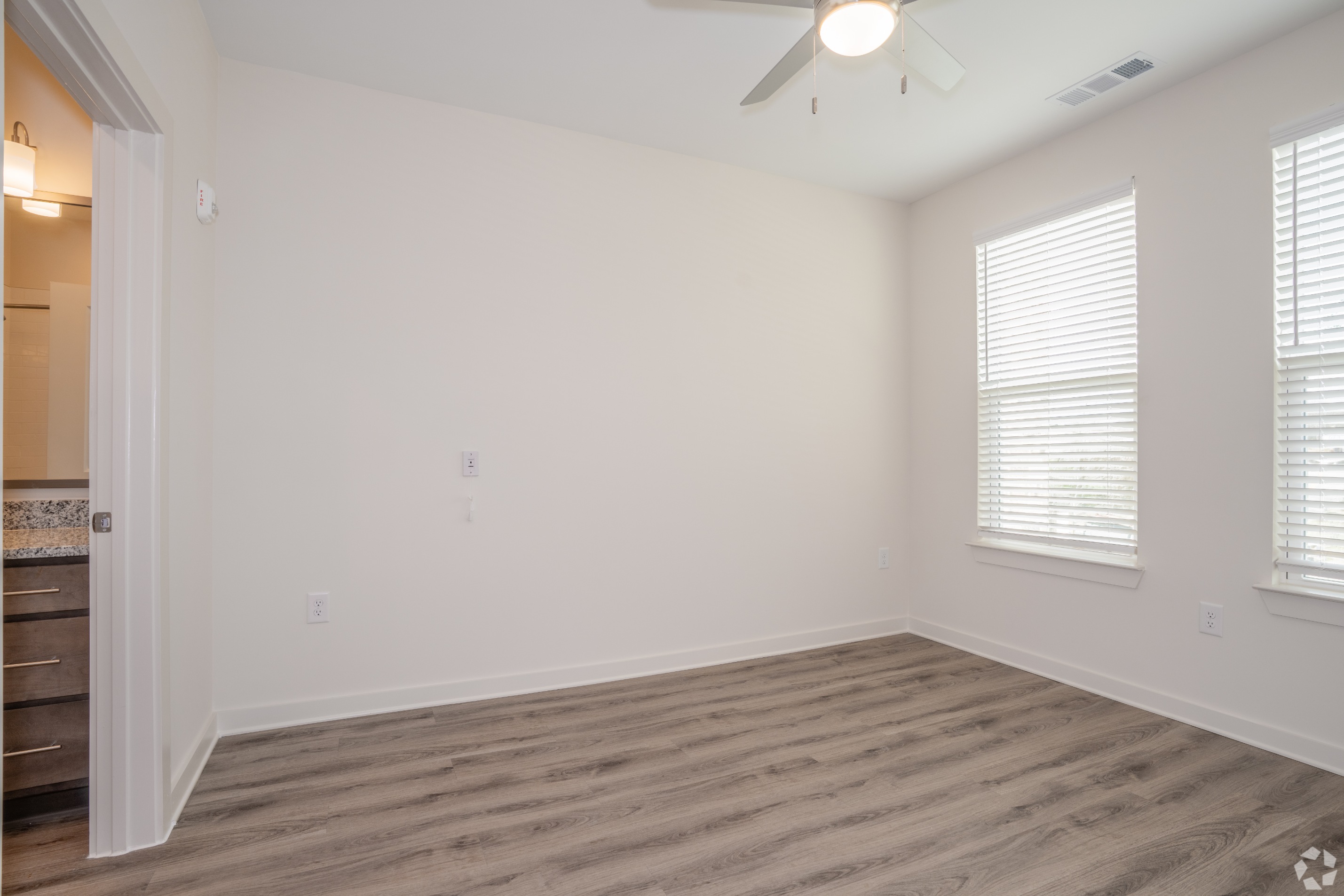 Bedroom with view of attached bathroom and 2 windows
