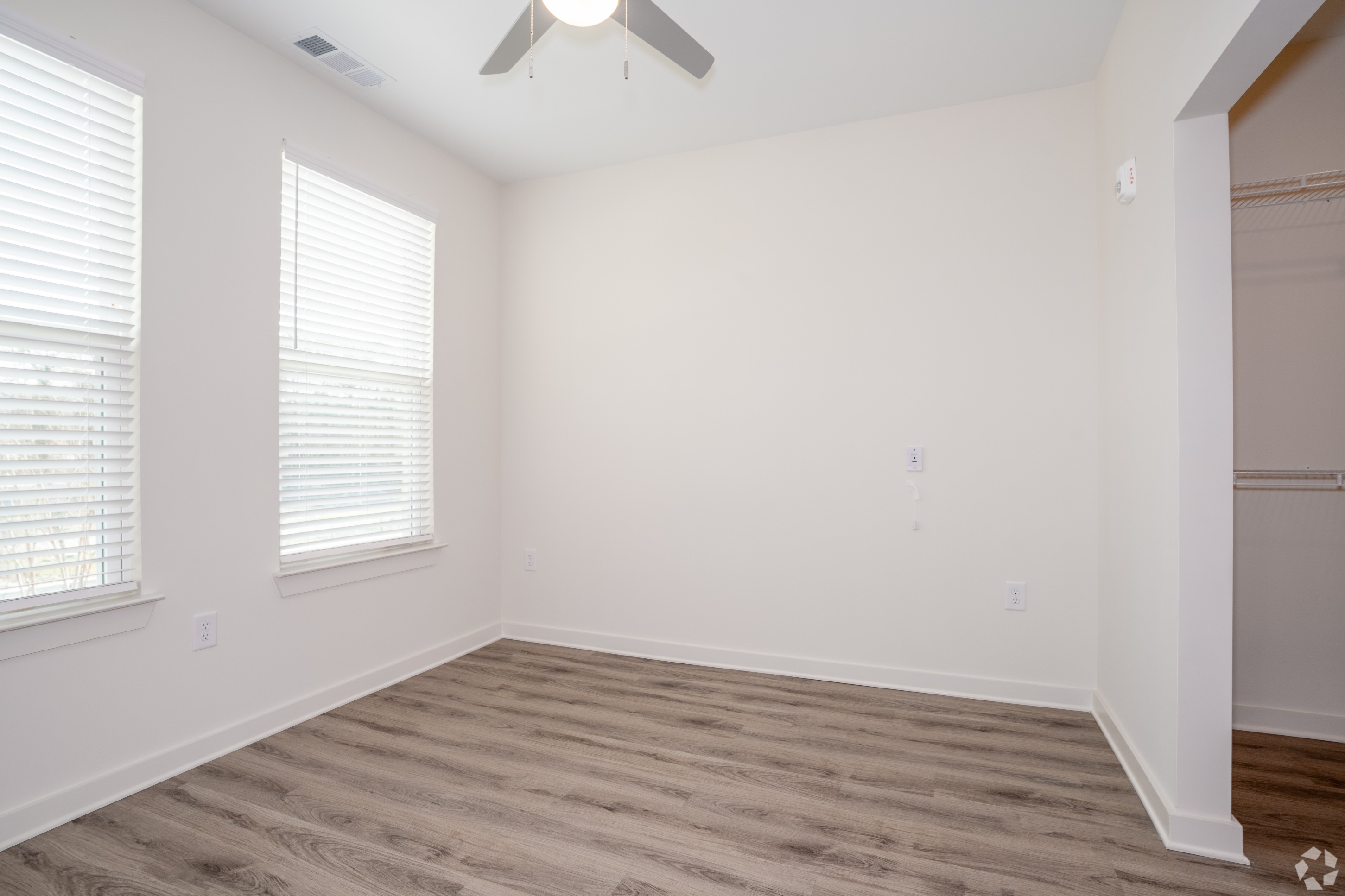 Bedroom with view of walk-in closet and 2 windows 