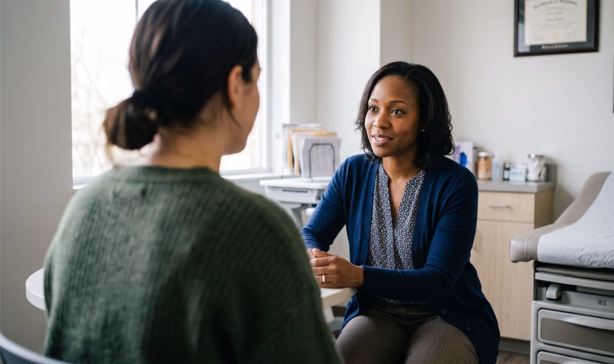 Clinician talking with a patient while Freed's scribe captures the conversation and adapts into SOAP note format