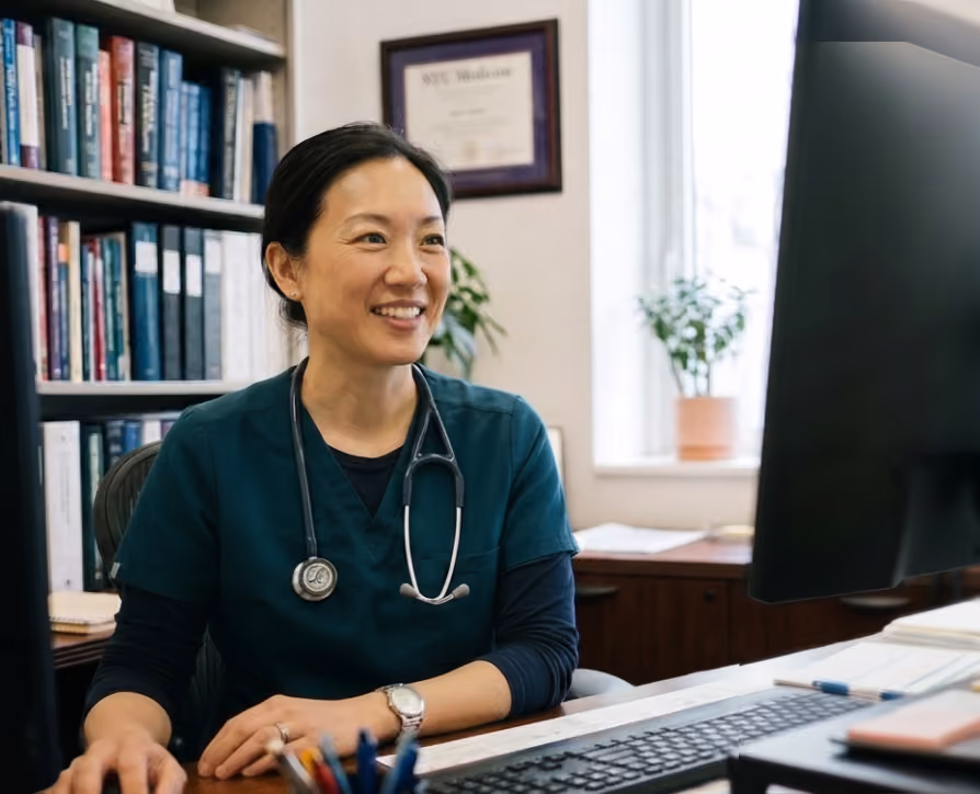 Clinician with a stethoscope smiling at a patient, with Freed's AI Chat with Clinical Evidence answer card showing a cited clinical answer pulling from 50+ verified sources.