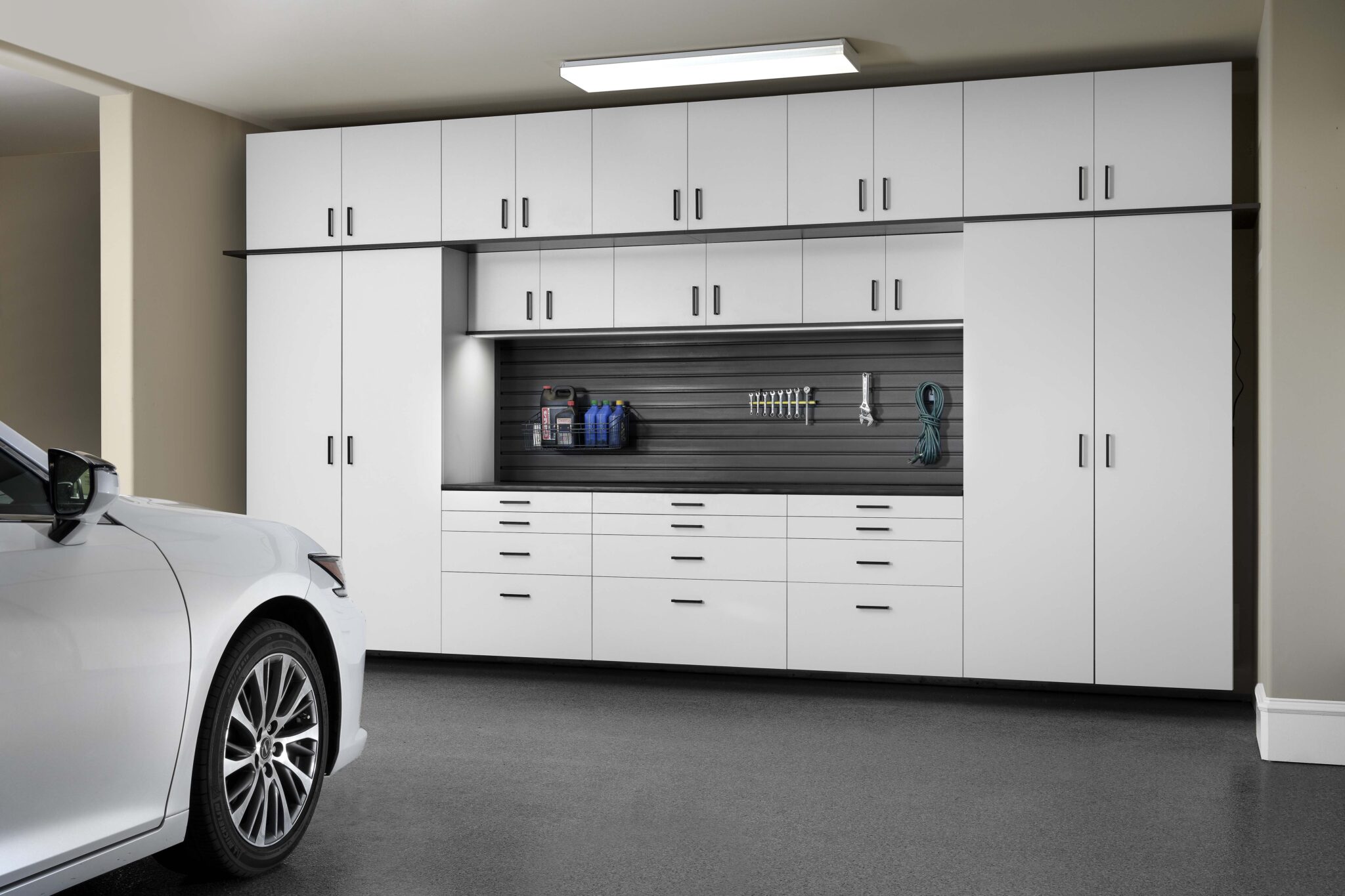Organized garage with white cabinets