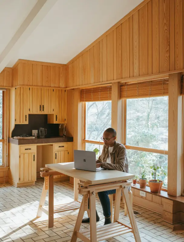 Person relaxing and working on a laptop in a cozy living room