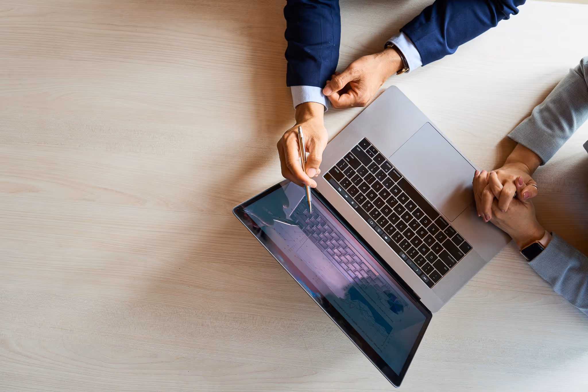 Professionals reviewing data on a laptop in a modern workspace