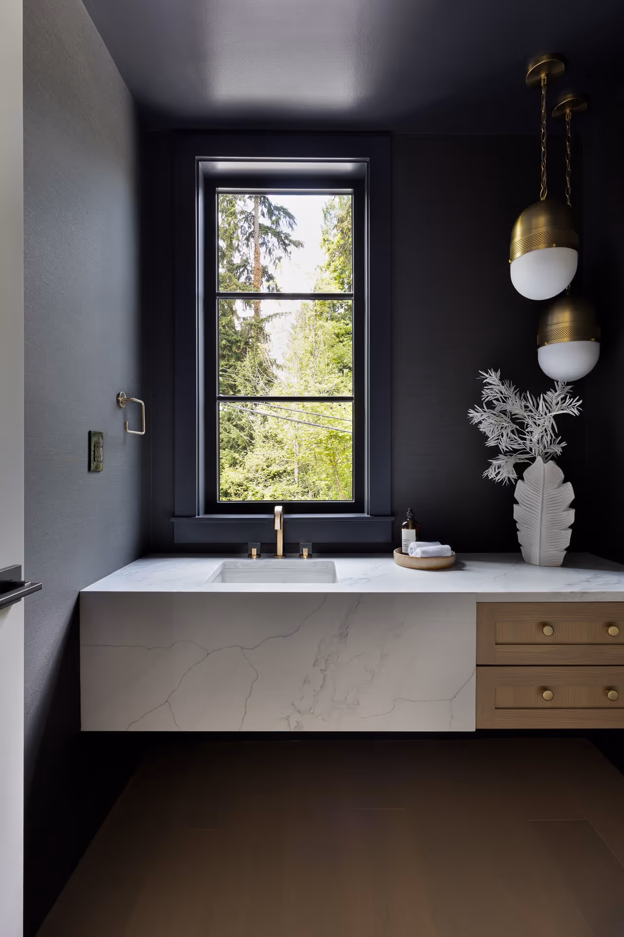 Modern bathroom interior with bathtub, dark walls and natural window light