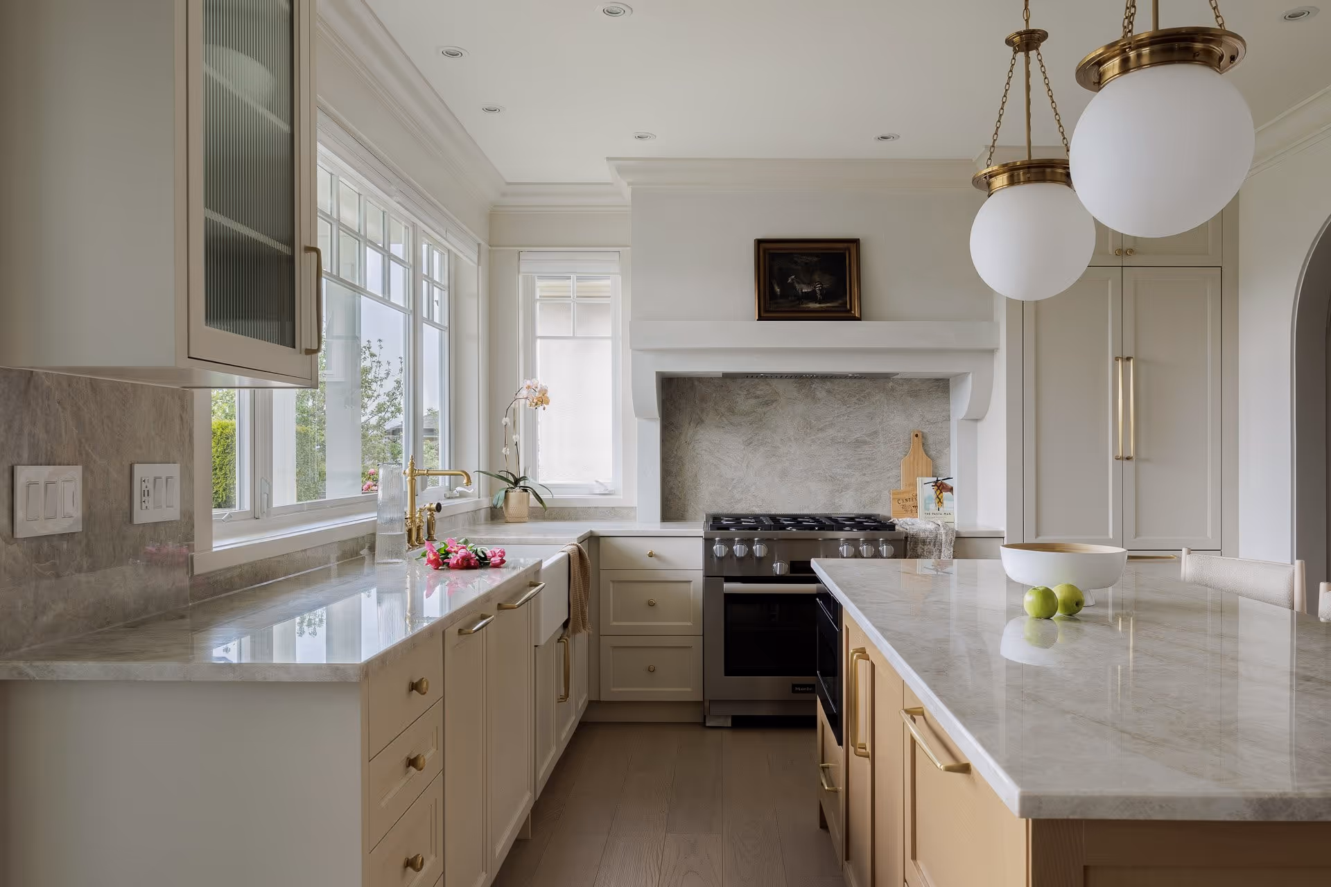 Modern kitchen interior with marble countertops, wood cabinetry and natural light