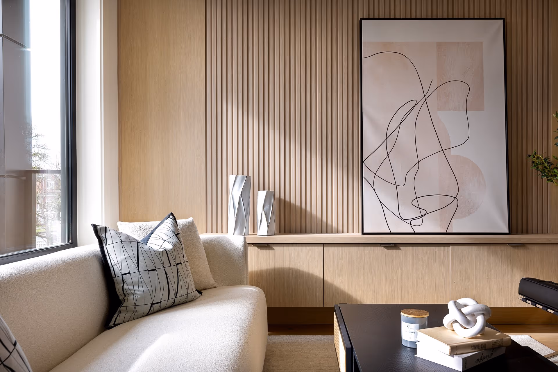 Modern living room detail with wood paneling, sofa seating and natural light
