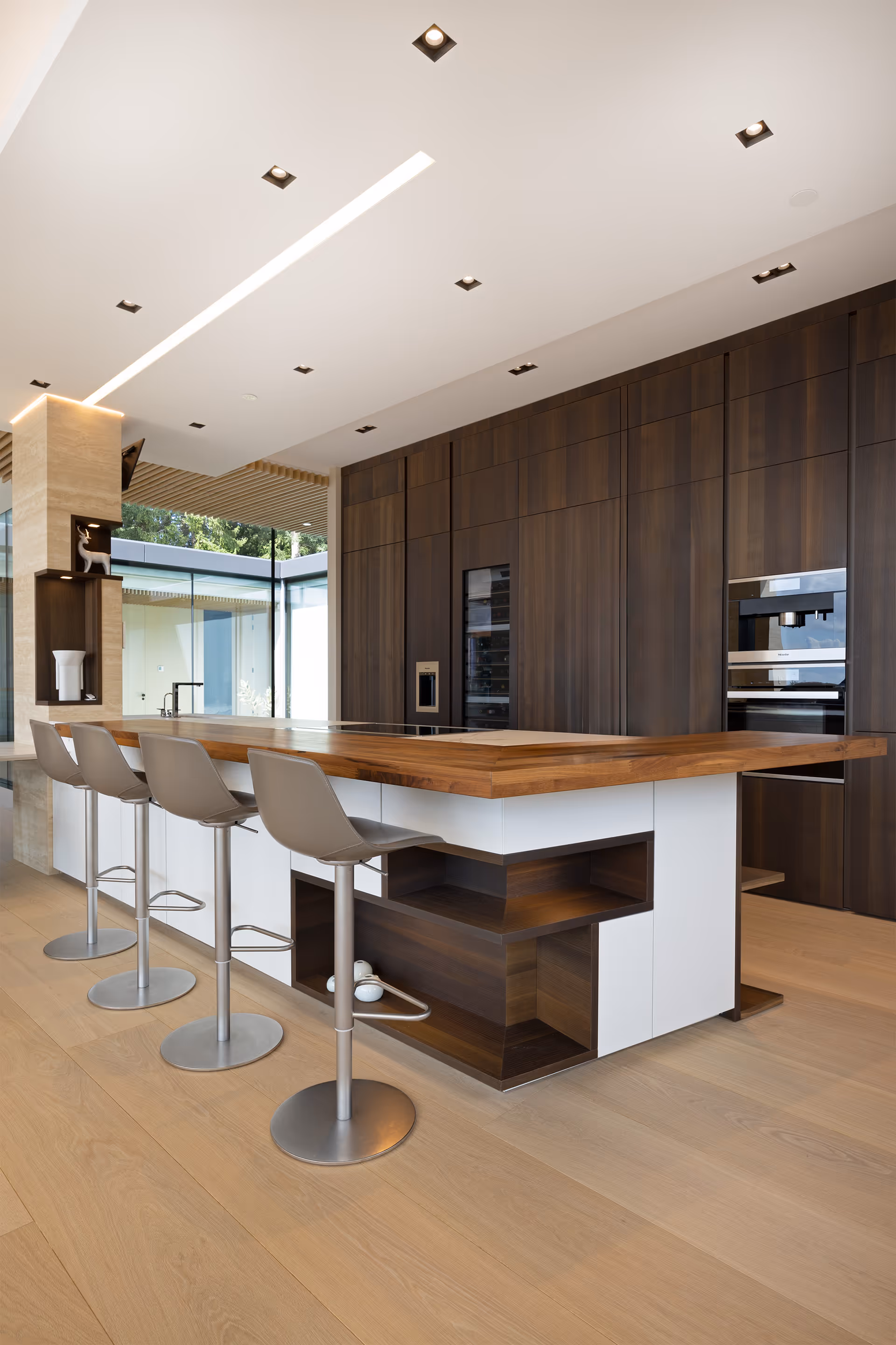 Modern kitchen with large island, bar seating, and wood cabinetry, residential interior photography