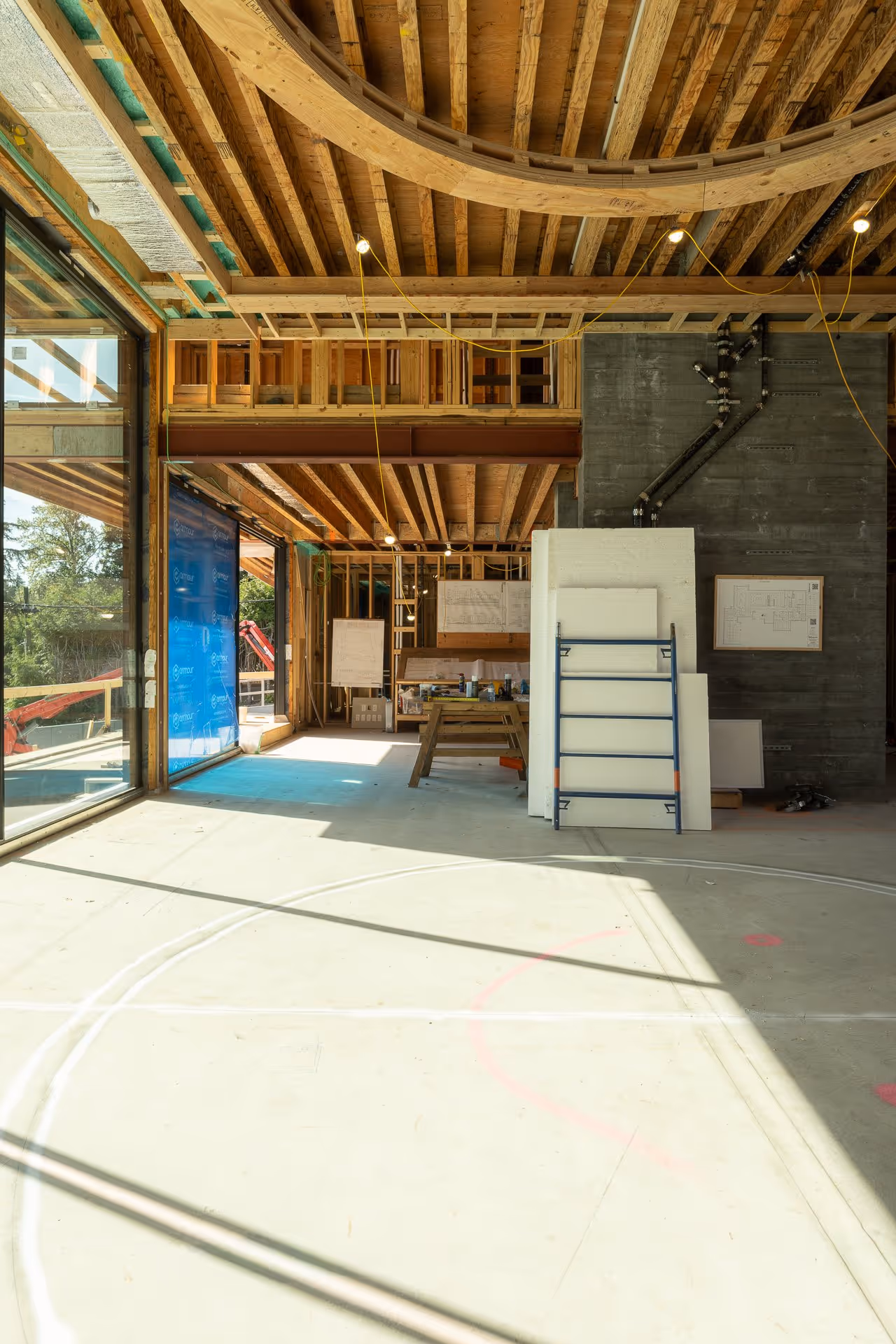 Construction site interior with exposed wood framing and natural light, residential building in progress photography