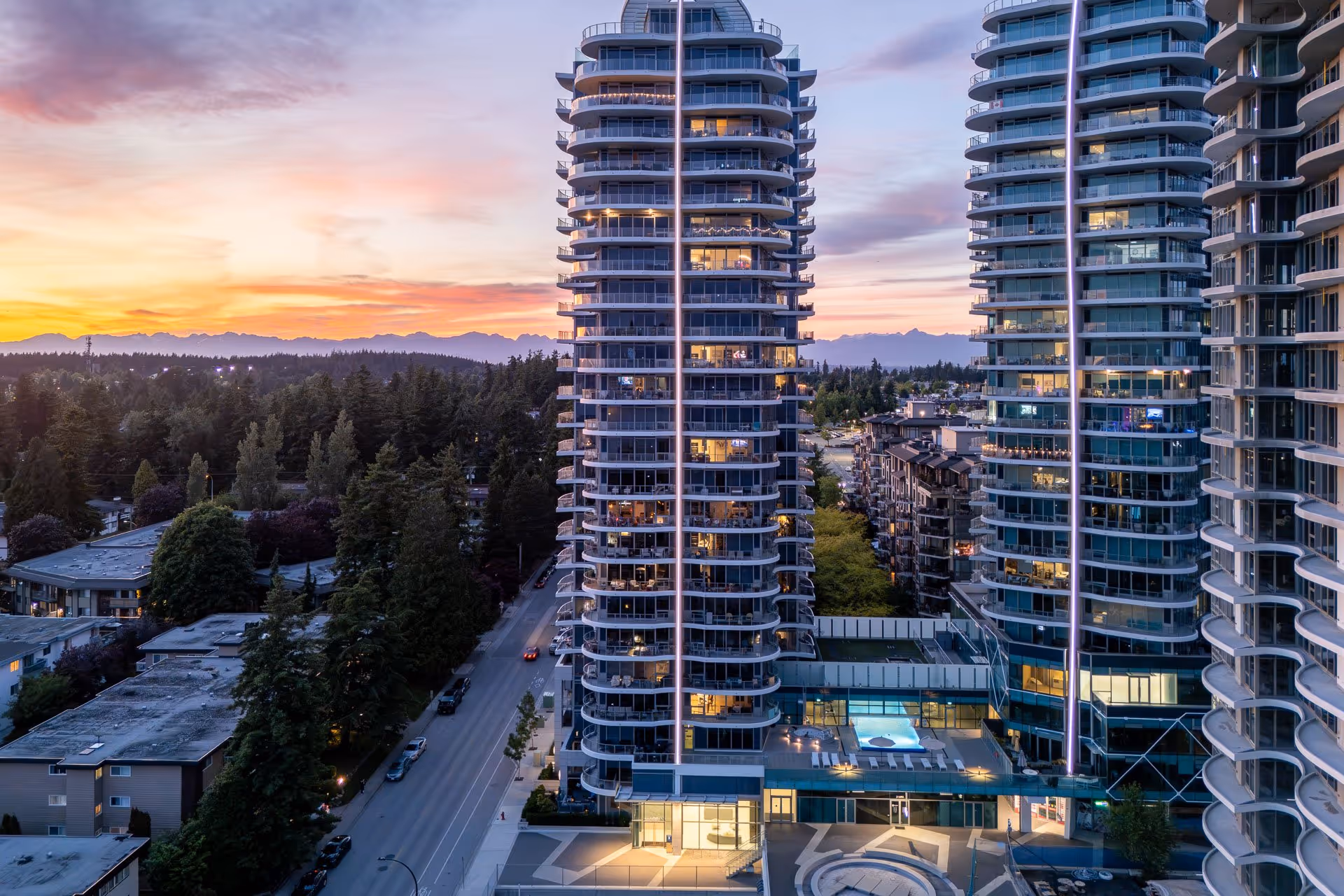 Modern residential towers at sunset with cityscape and mountains, Vancouver architecture photography