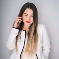 Professional portrait of a woman in white blazer with long hair and red lipstick, studio background, business photography