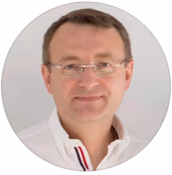 Professional headshot of a man wearing glasses and white shirt, neutral background, business portrait photography