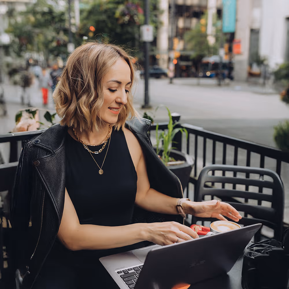 Architectural photographer working on laptop at outdoor cafe, lifestyle business portrait in Vancouver