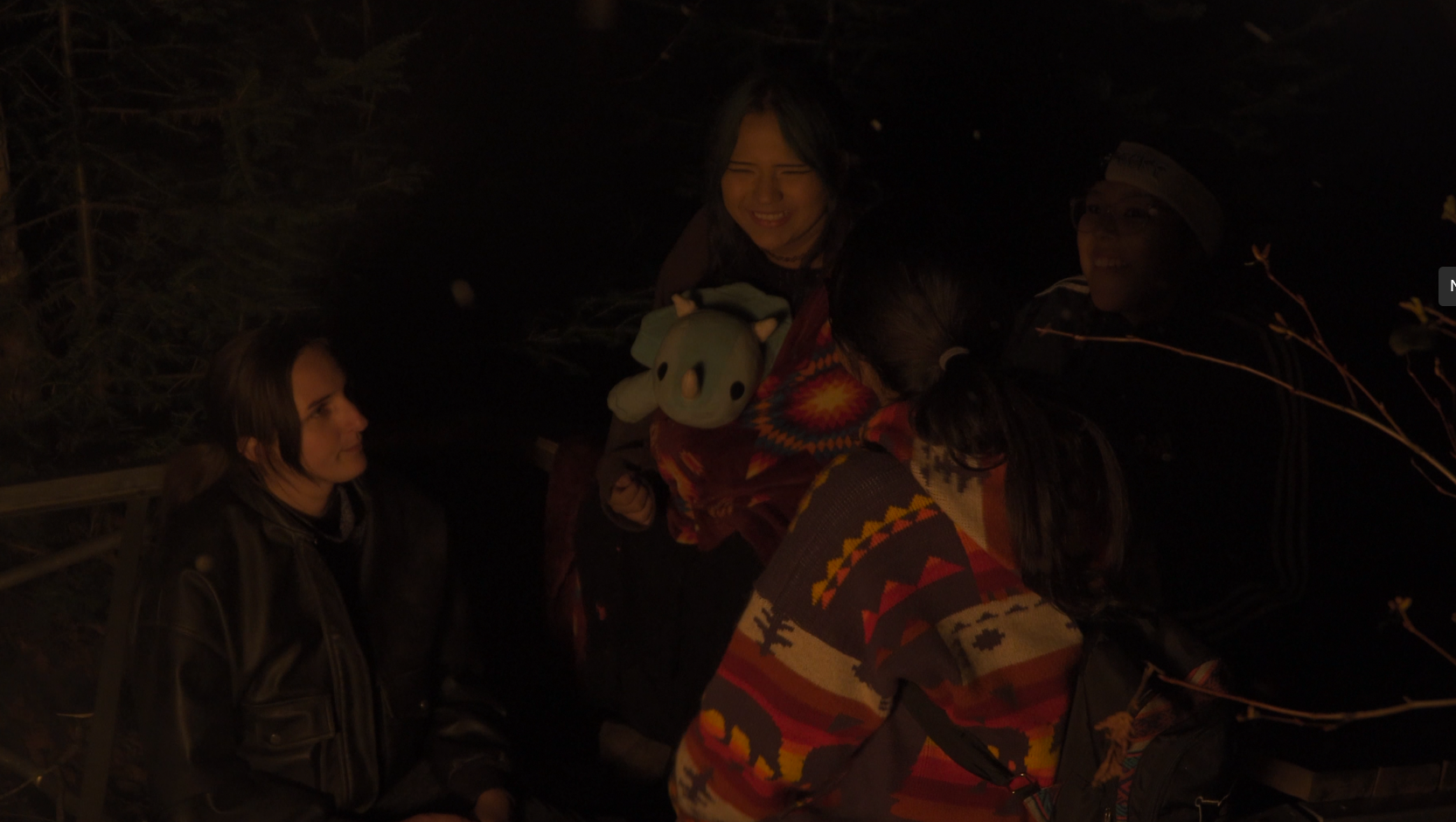 Photo of three youth at a campfire