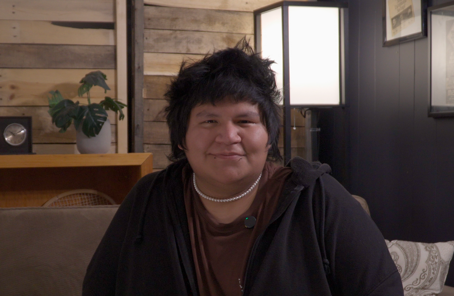 Photo of Malakai Mawageesick smiling wearing a pearl necklace