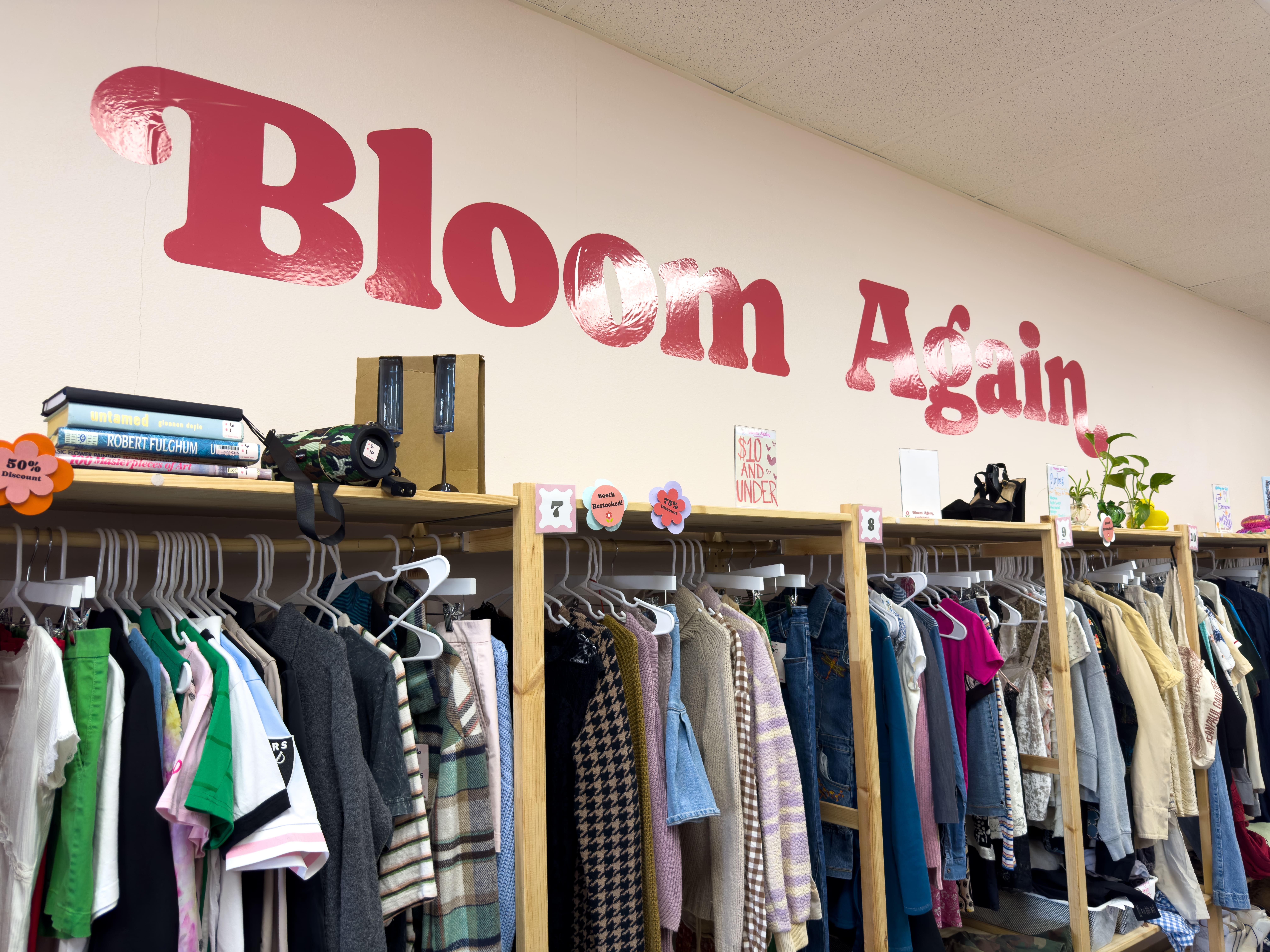 interior of bloom again in fountain valley showing vendor booths stacked with clothing and home goods