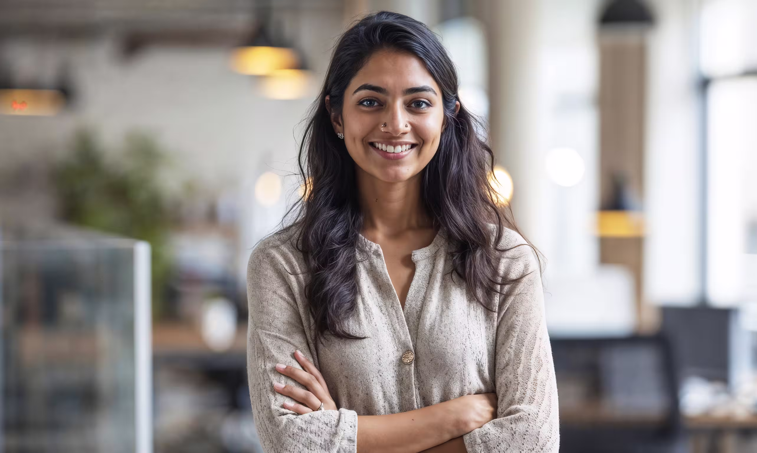 Professional portrait at a desk with soft bokeh lights.