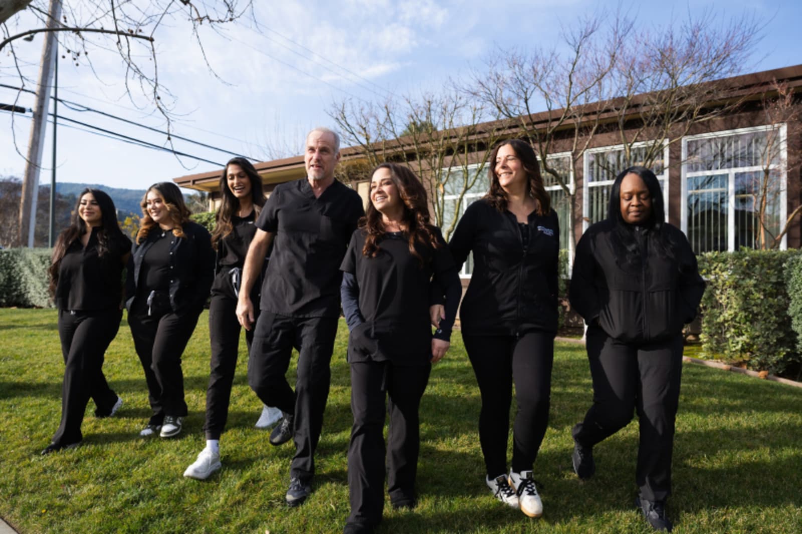 Smile Haus Dental Studio team standing together outdoors in professional attire.
