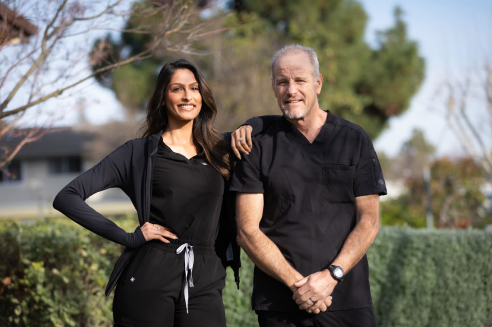 Dr. Patel and female team member posing together outdoors at Smile Haus Dental Studio