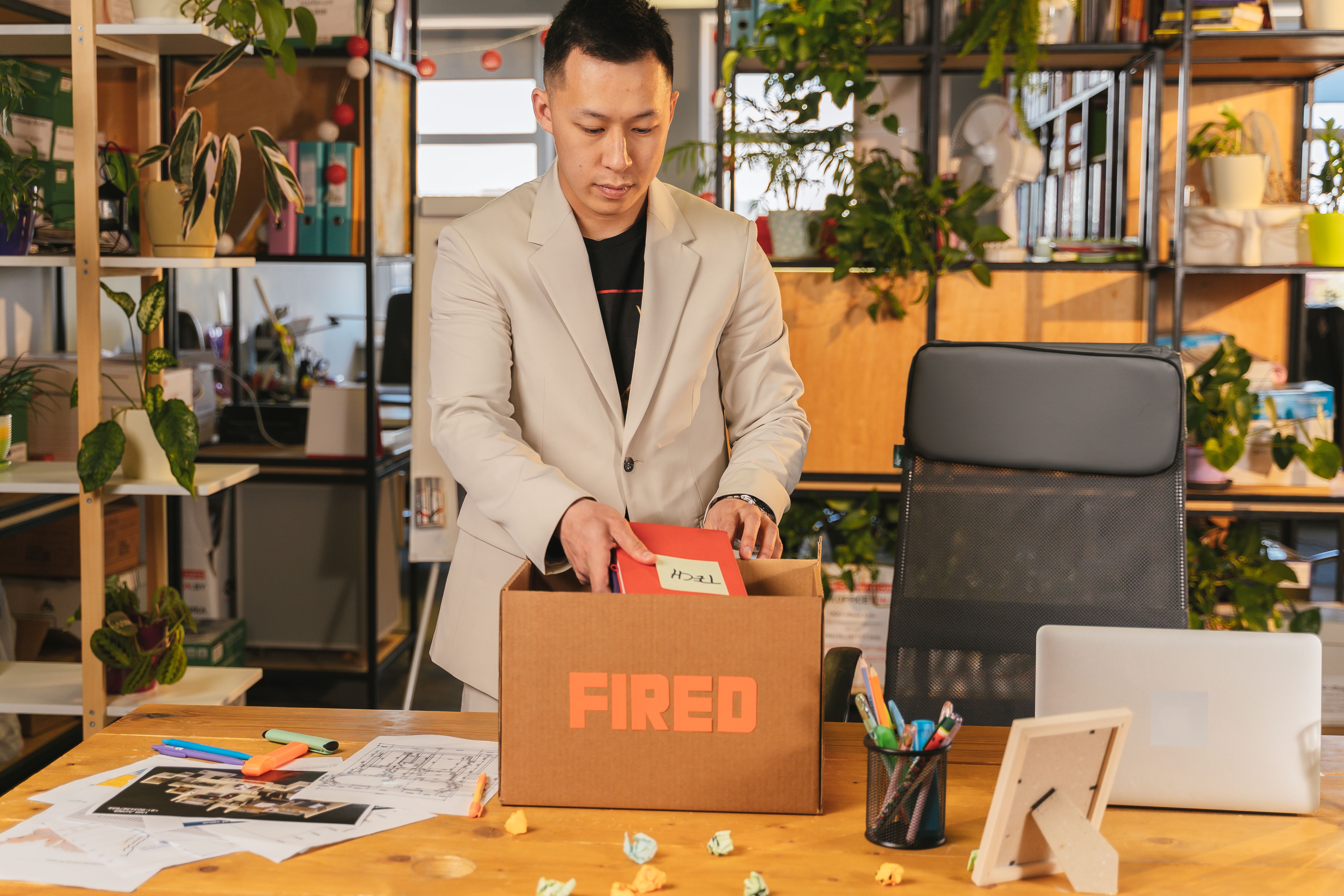 Employee sliding a resignation envelope across a manager's desk