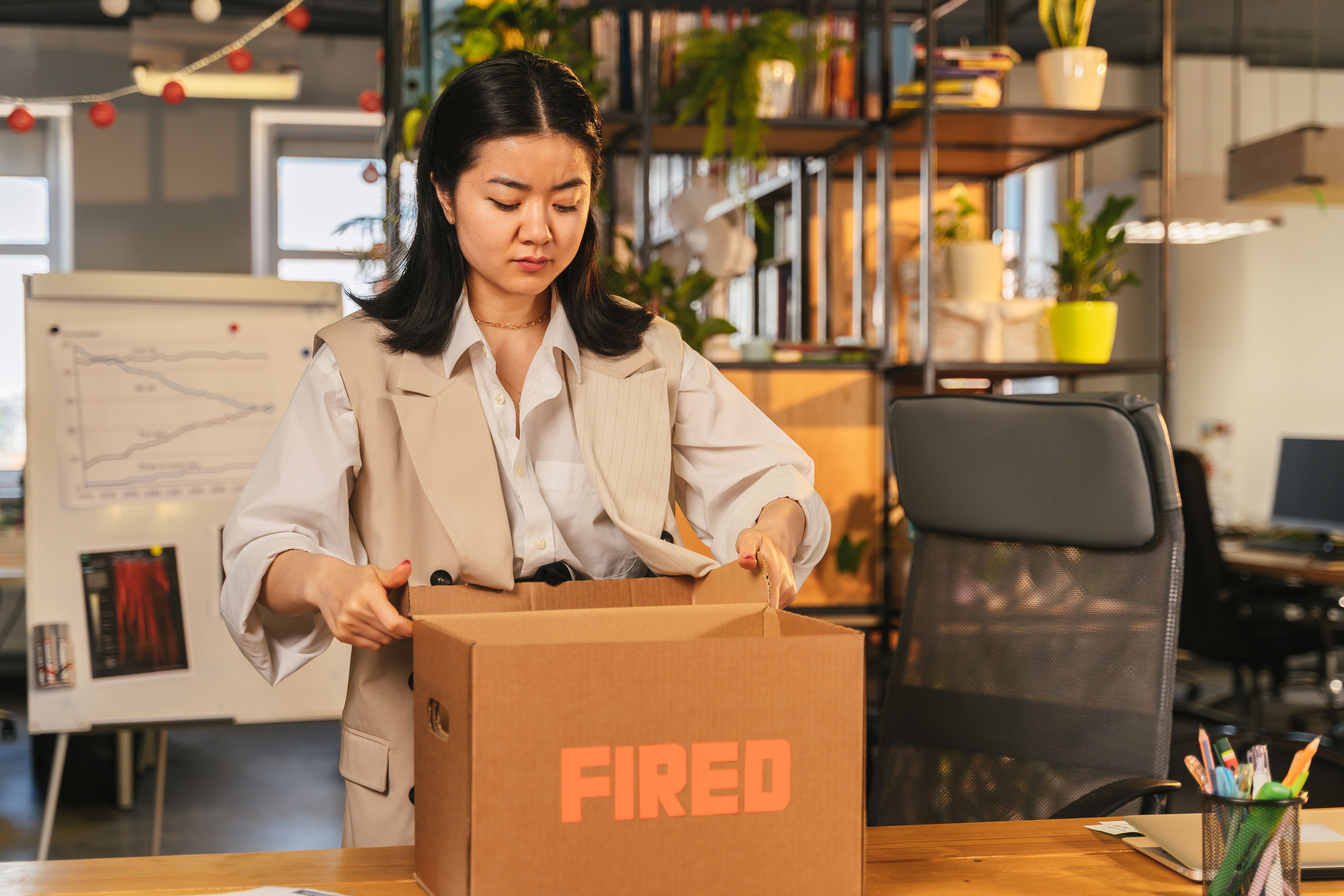 Personal belongings in a cardboard box on an empty office desk