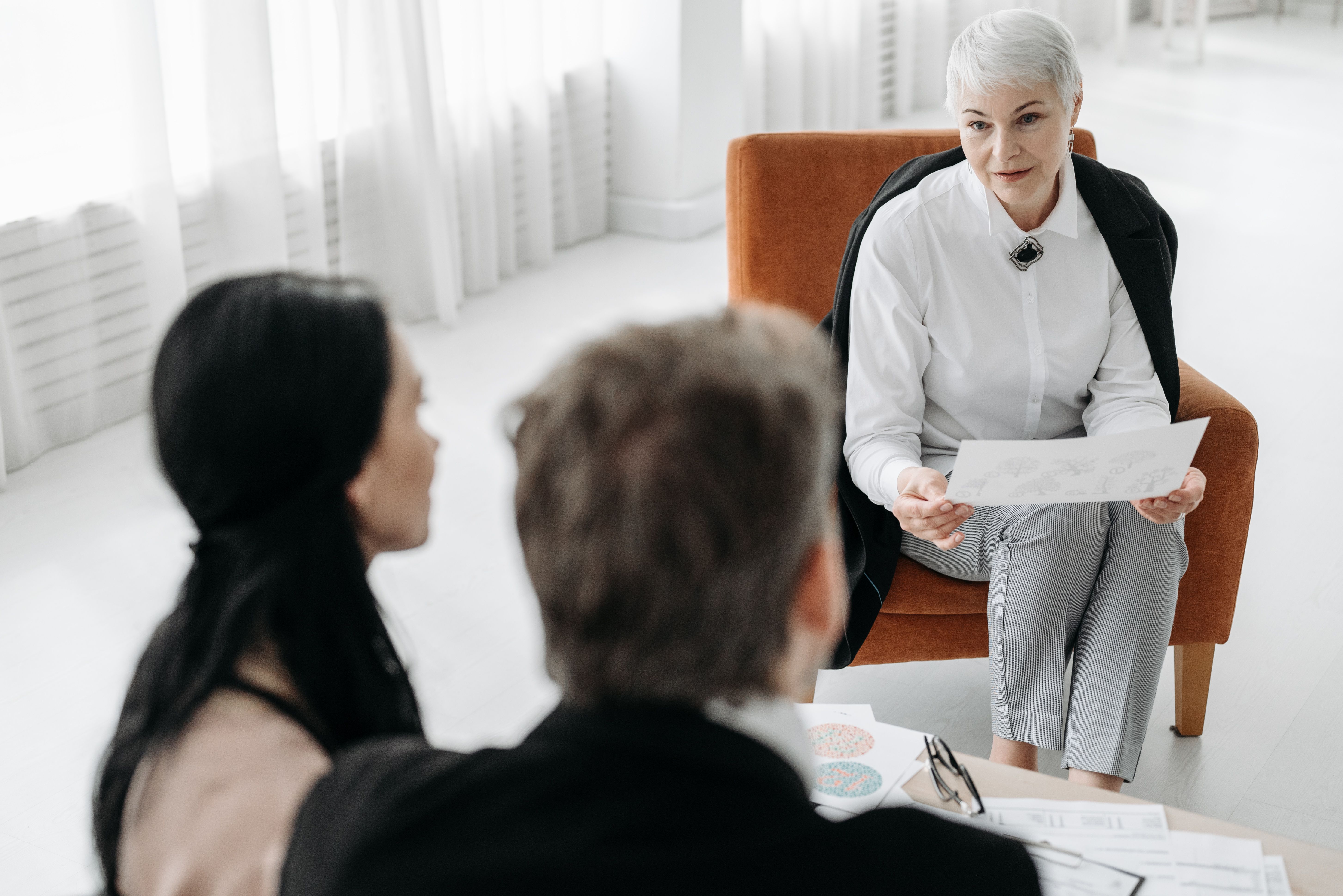 Silver-haired advisor listening intently in a family meeting