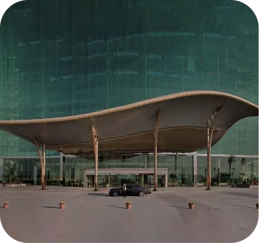 Business Setup In Dubai: Modern glass building with curved architectural canopy