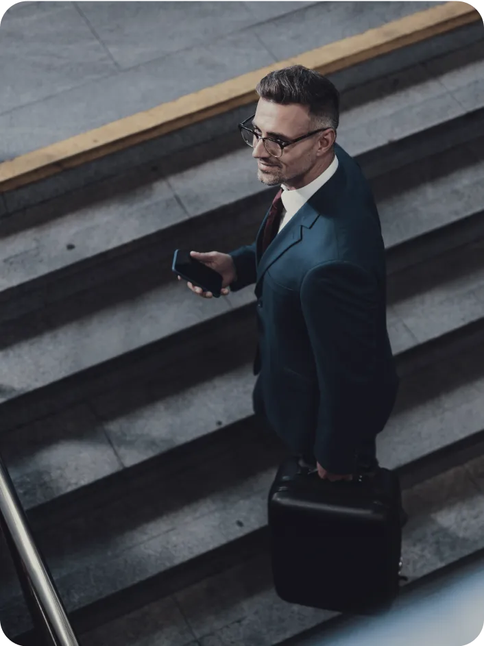 Business Setup In Dubai: Professional businessman with smartphone on urban stairs