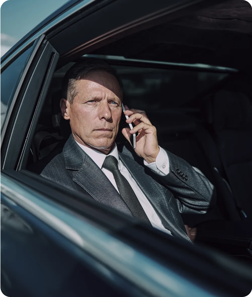 Business Setup In Dubai: Professional executive on phone inside luxury car
