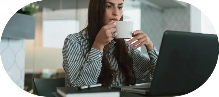 Professional working on Company Formation in Dubai, drinking coffee at laptop