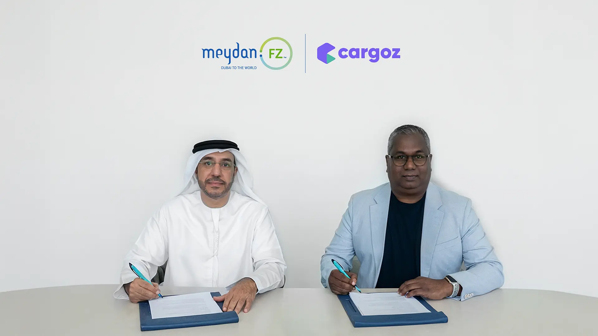 2 Men sitting ready to sign a partnership, Meydan Freezone x Cargoz