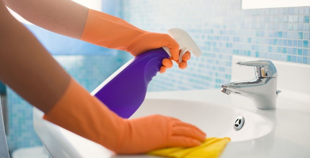 Woman Doing Chores Cleaning Bathroom At Home