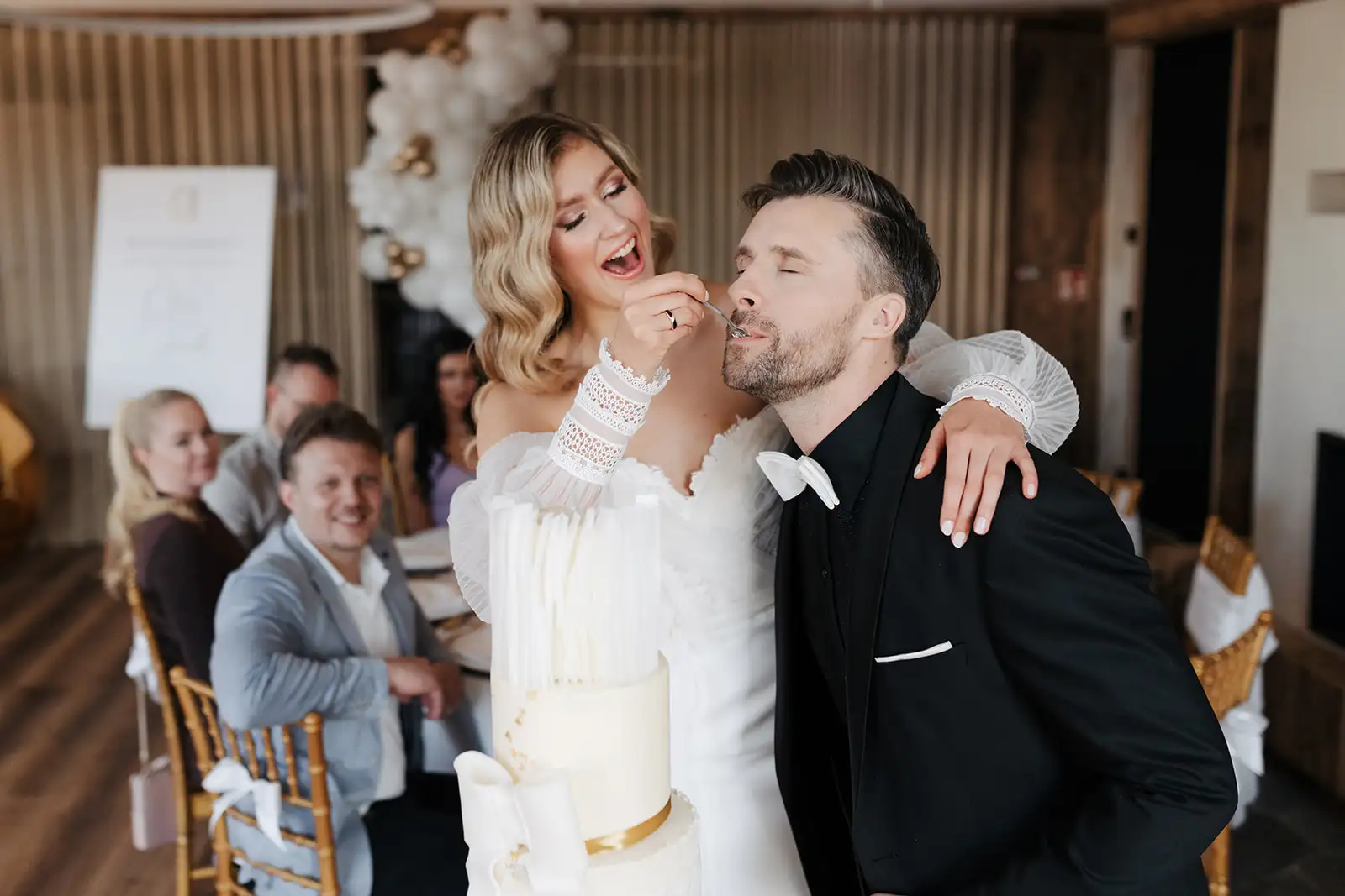 Hochzeit Hochzeitstorte Brautpaar beim Anschneiden Bräutigam probiert