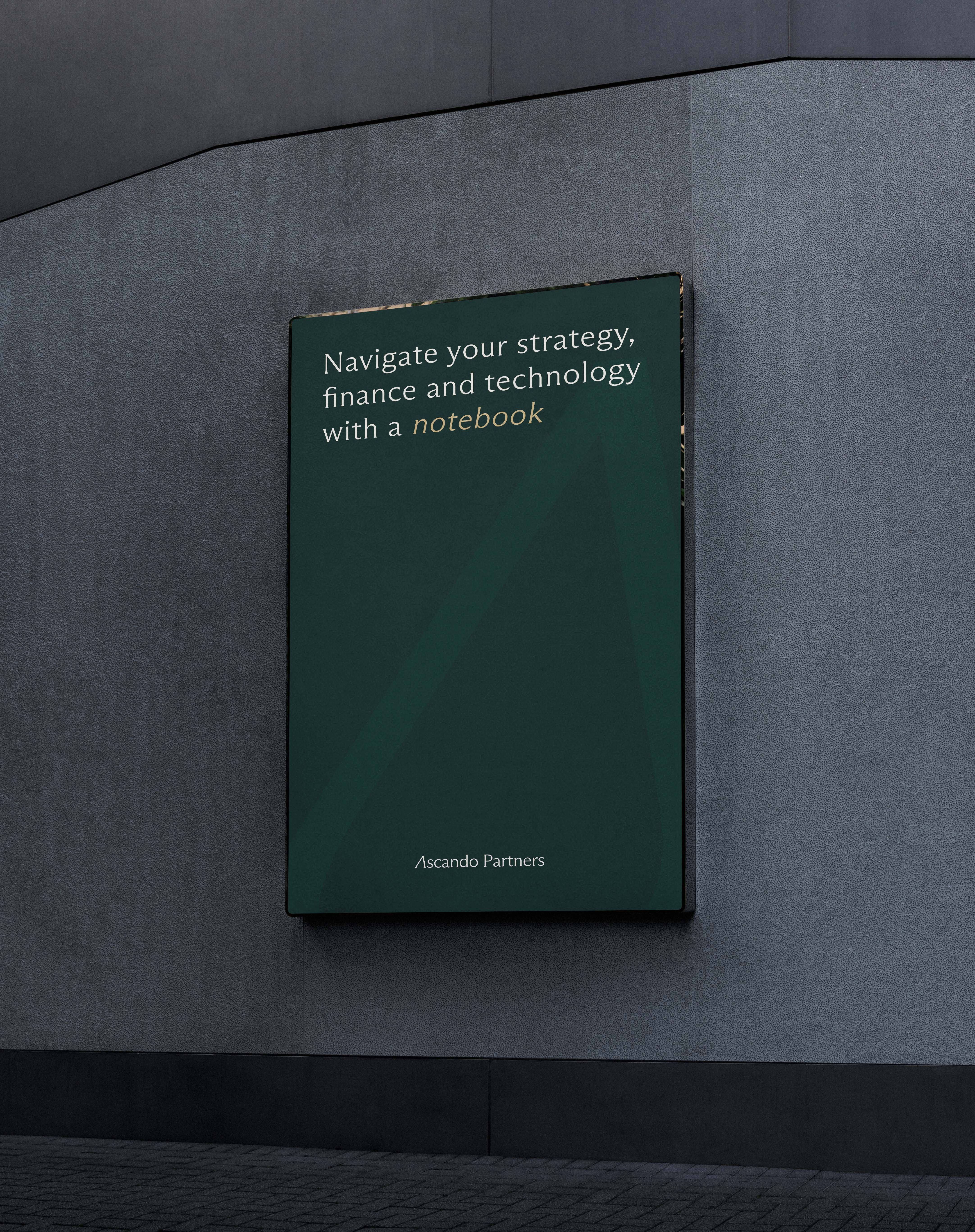 Outdoor billboard on a gray wall displaying: Navigate your strategy, finance and technology with a notebook, Ascendo Partners.