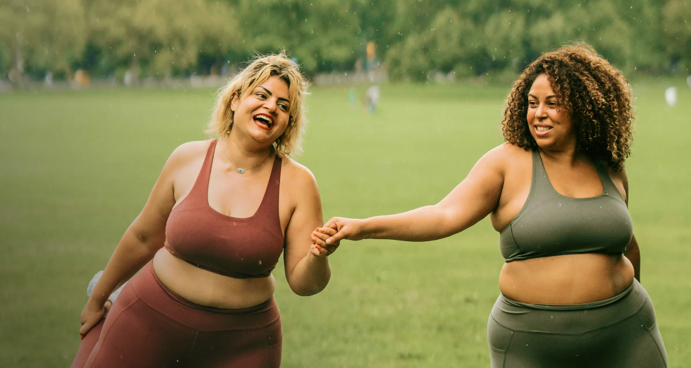 Two women holding hands outdoors, representing taking the next step in weight loss care
