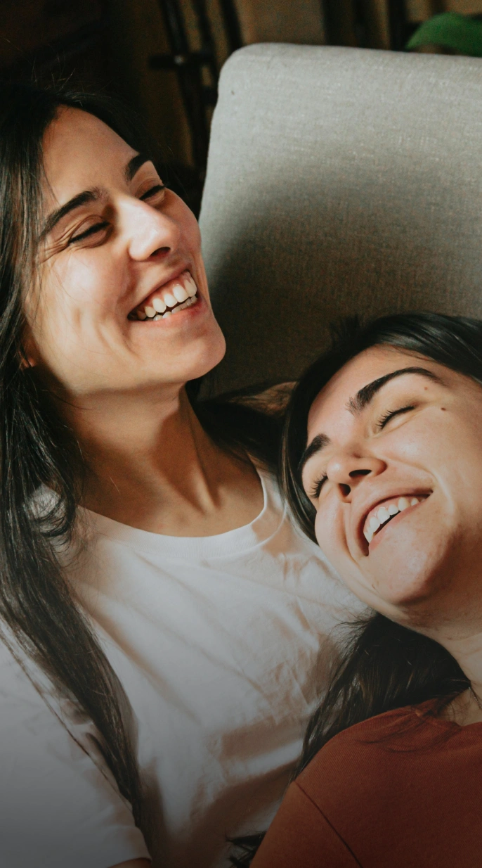 Two women smiling together, representing personalized hormone replacement therapy care