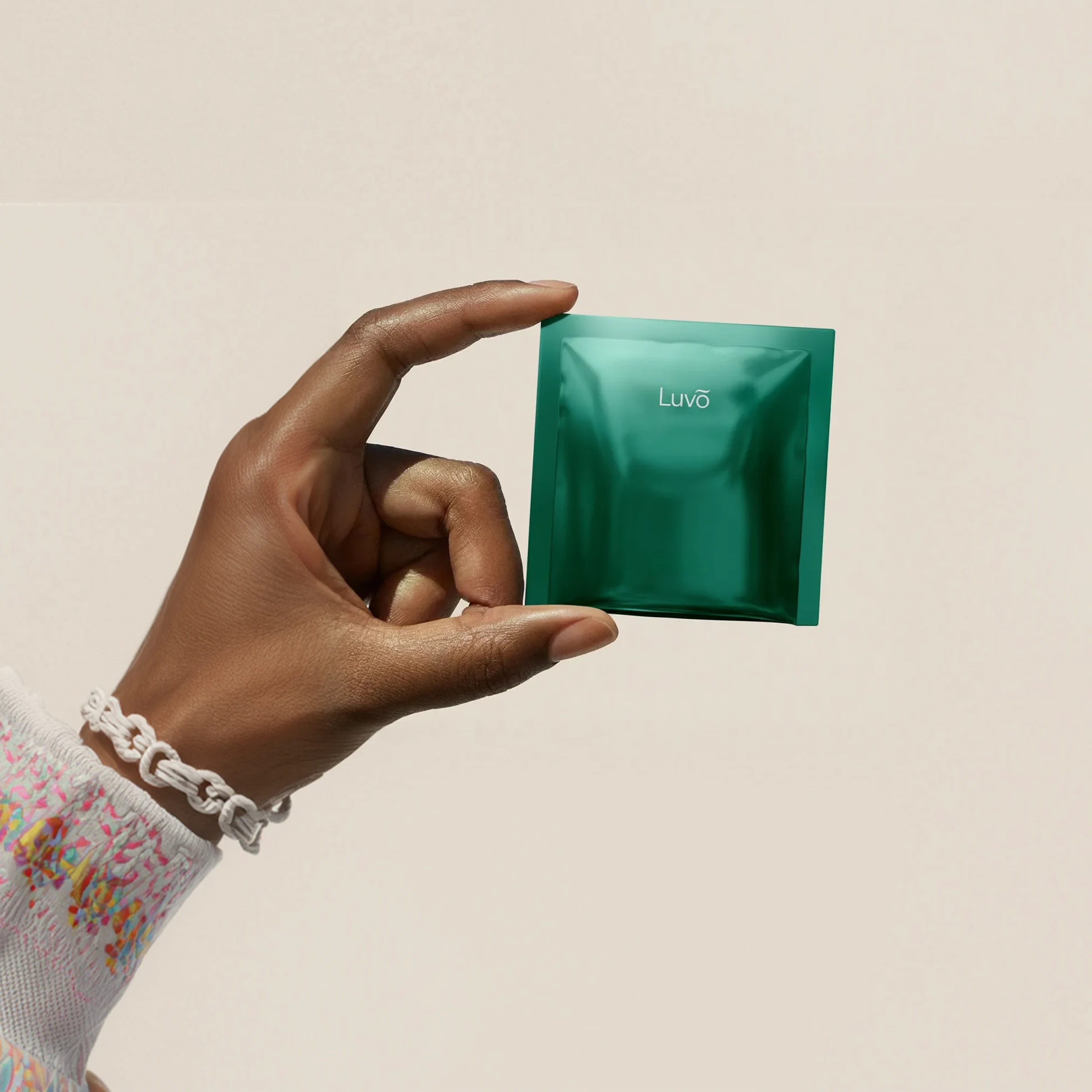 Hand holding a package of estradiol patches