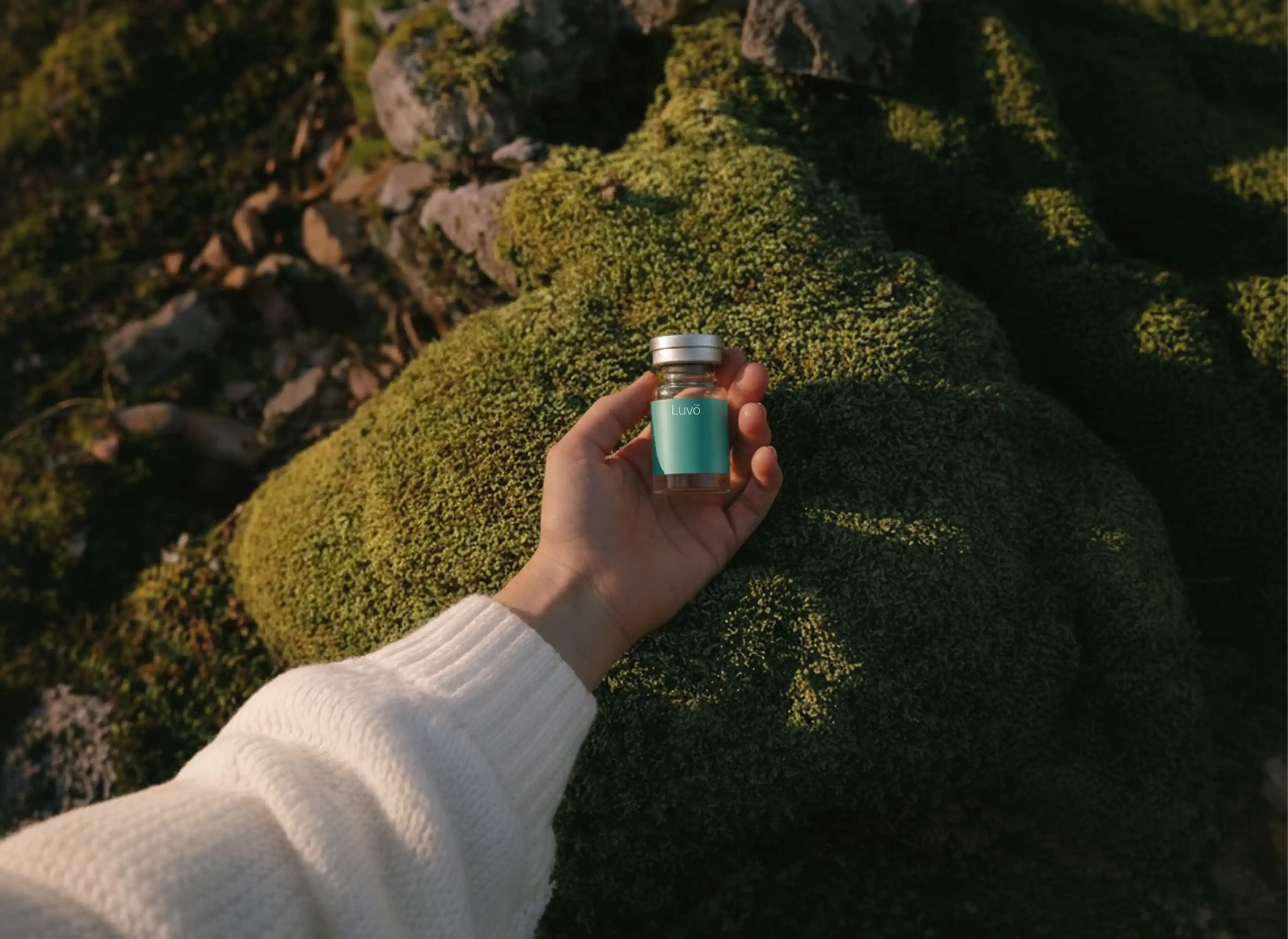 Hand holding a Sermorelin vial over moss