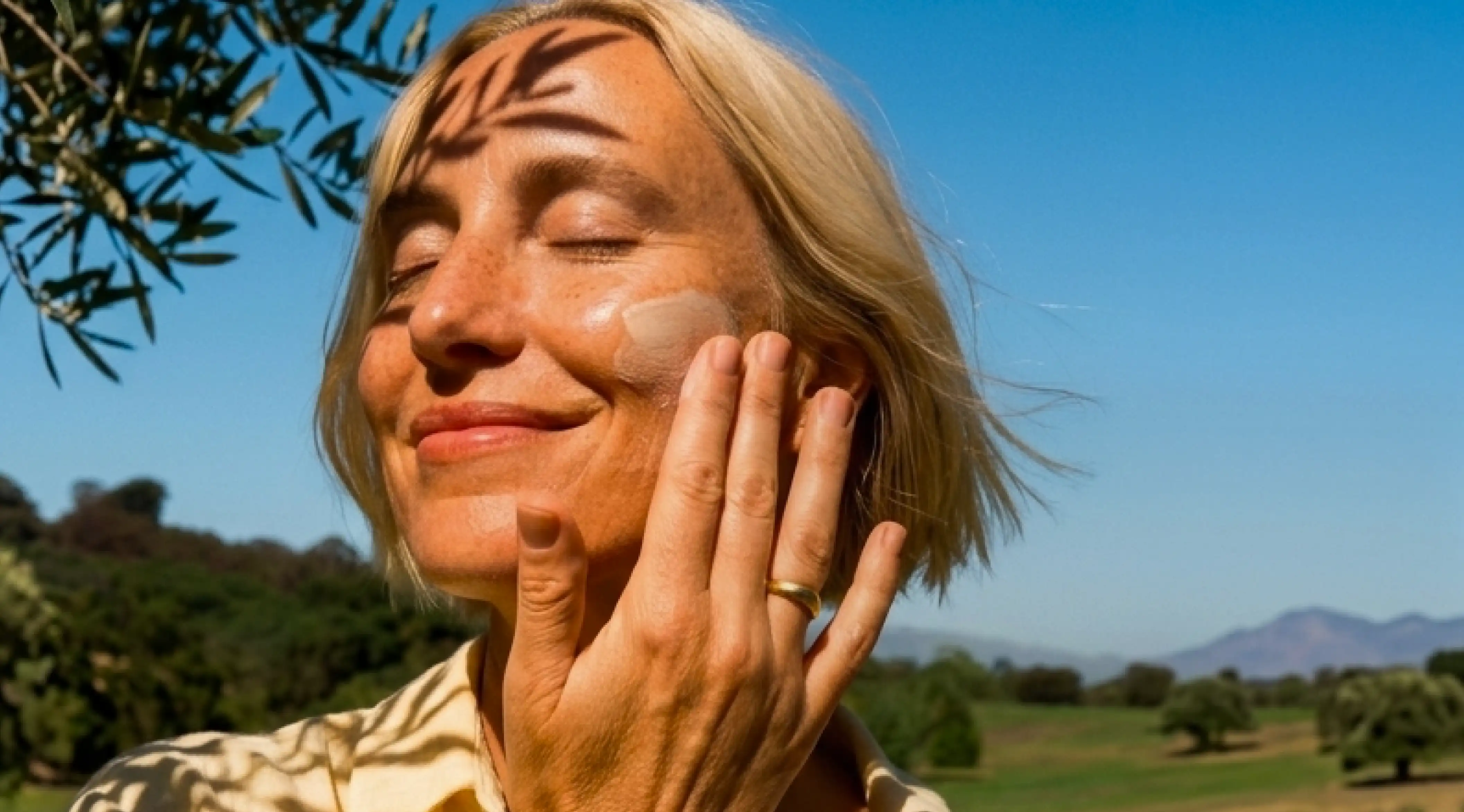 Woman applying prescription skincare cream outdoors