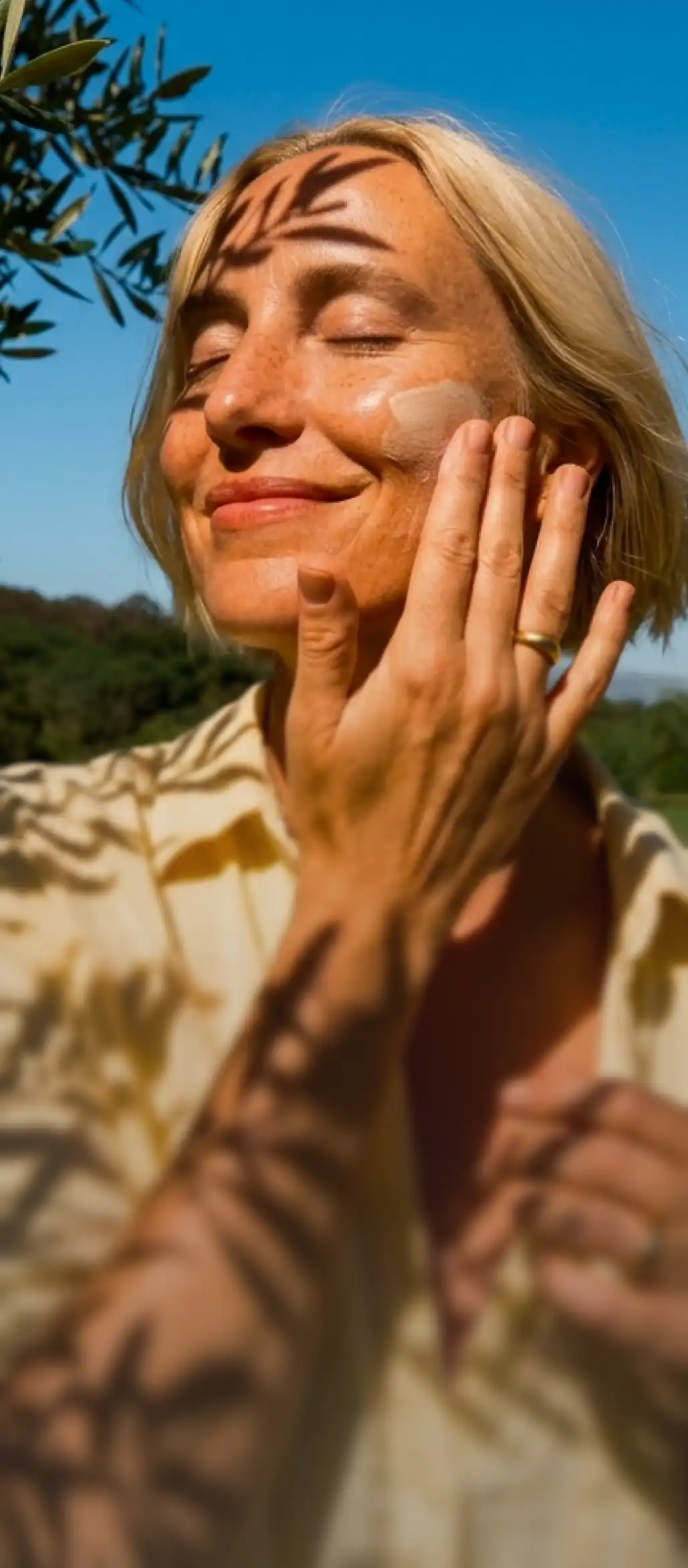 Woman applying prescription skincare cream outdoors
