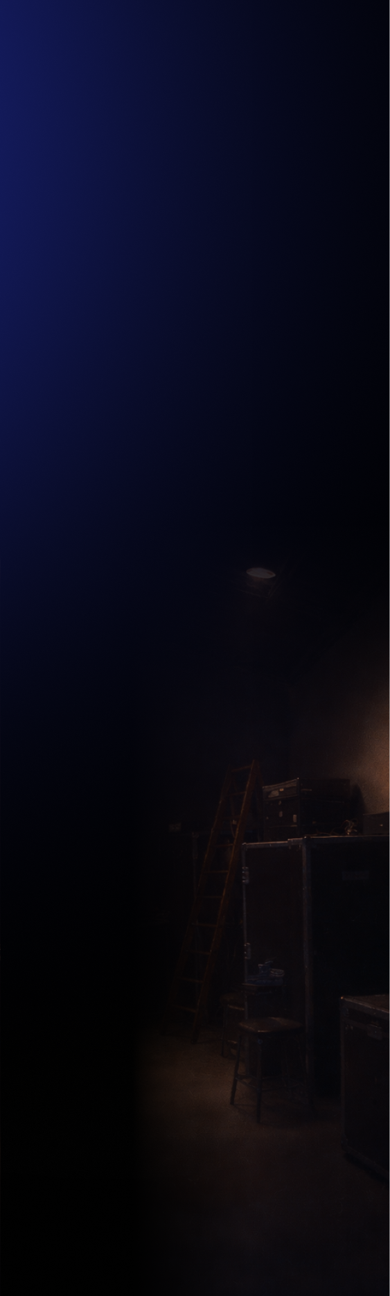 Dimly lit backstage area with a wooden ladder, stacked equipment cases, and a stool.