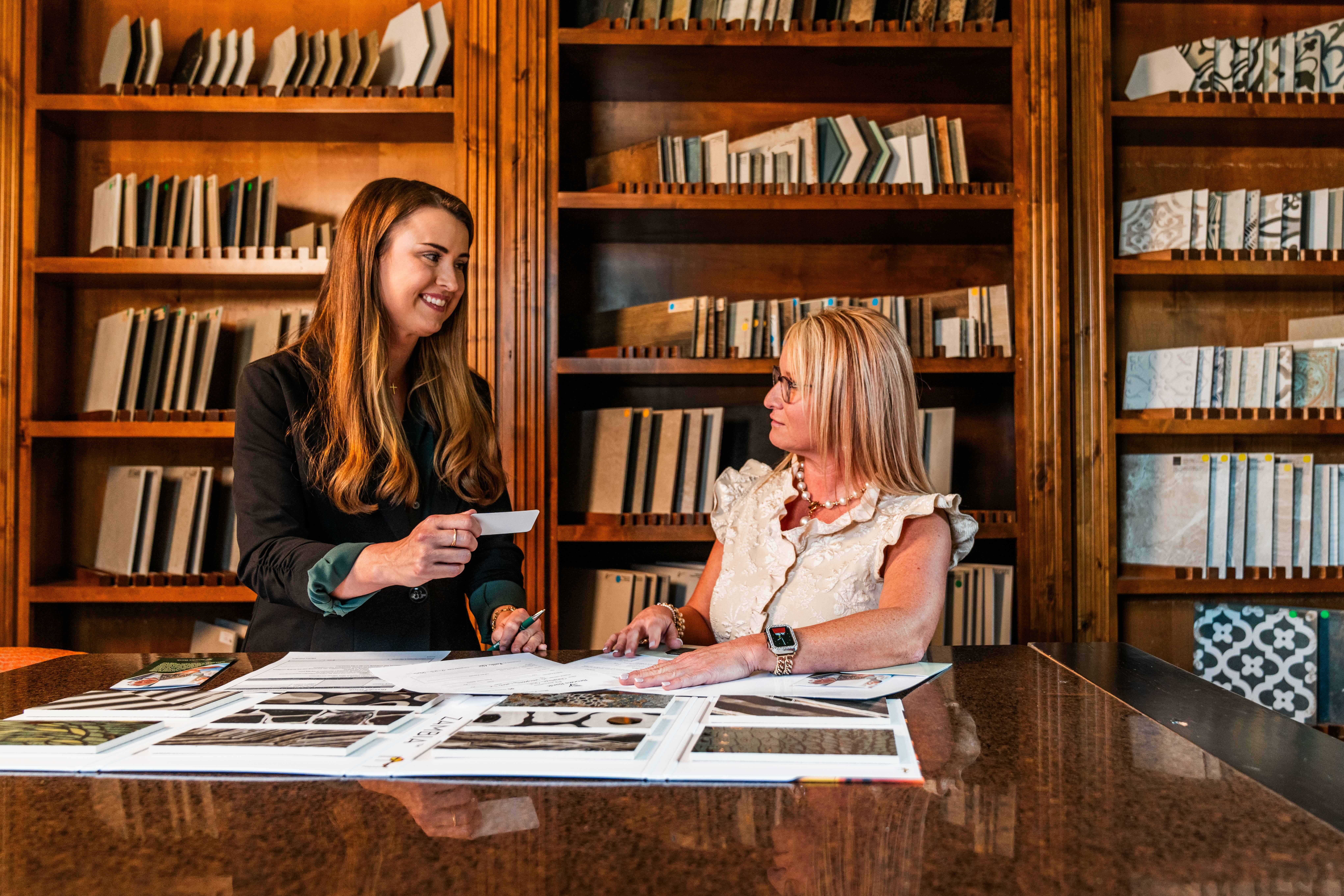 Brooks Bank Customer Heather Hill reviewing design plans and tile samples at her showroom