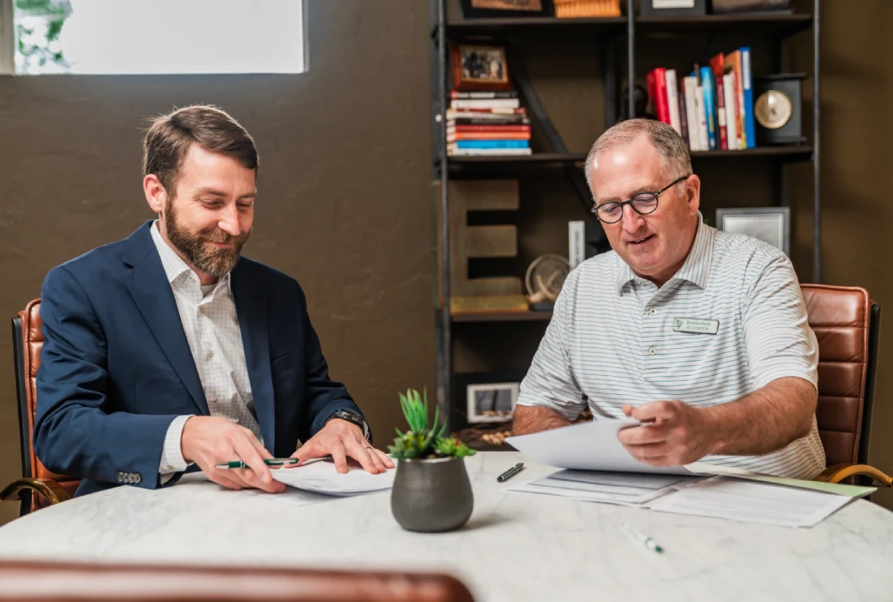 Brooks Bank Customer Blake Elliott reviewing paperwork with his Brooks Bank banker