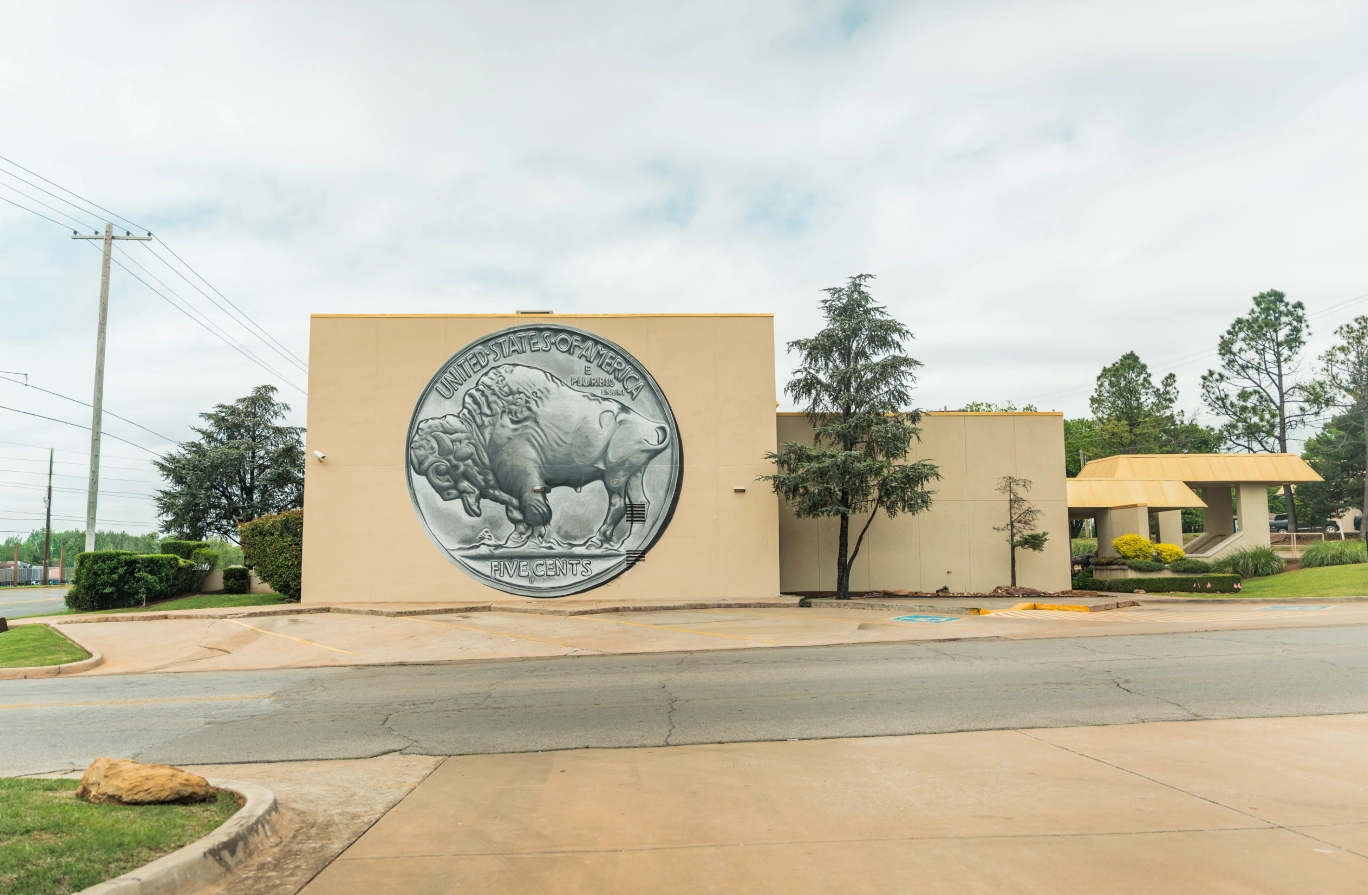The Brooks Bank Chickasha Grand Avenue branch with a large buffalo nickel medallion on its facade
