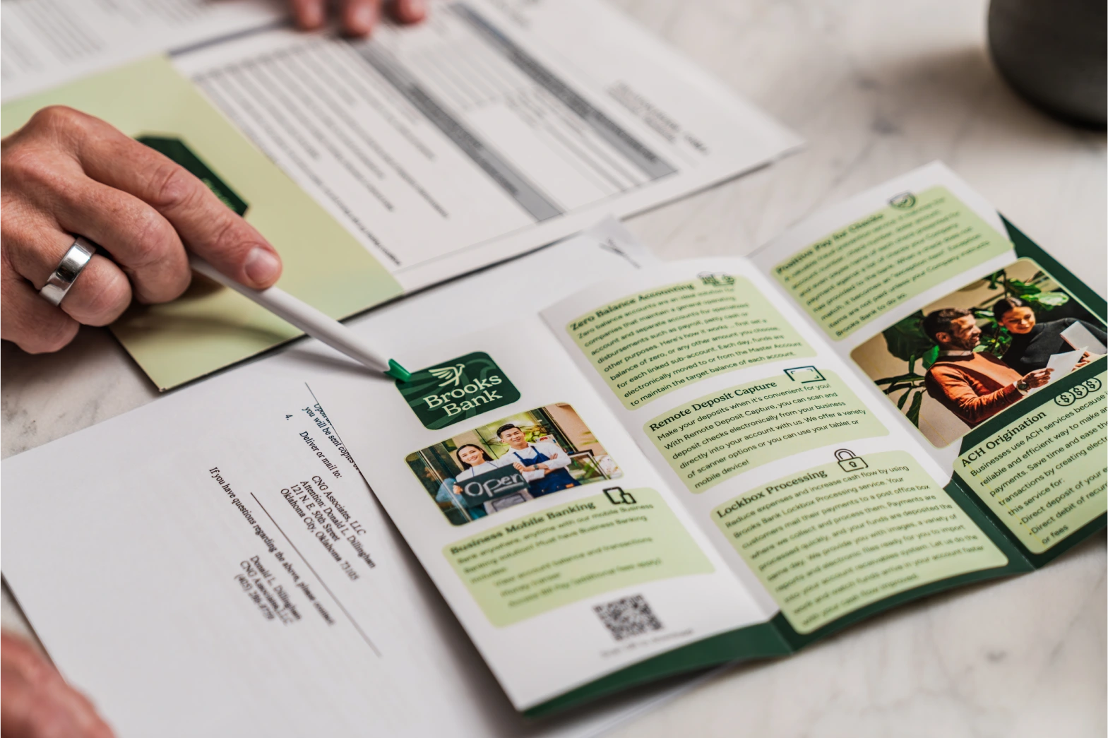 Brooks Bank business banking brochure open on a desk beside an account application